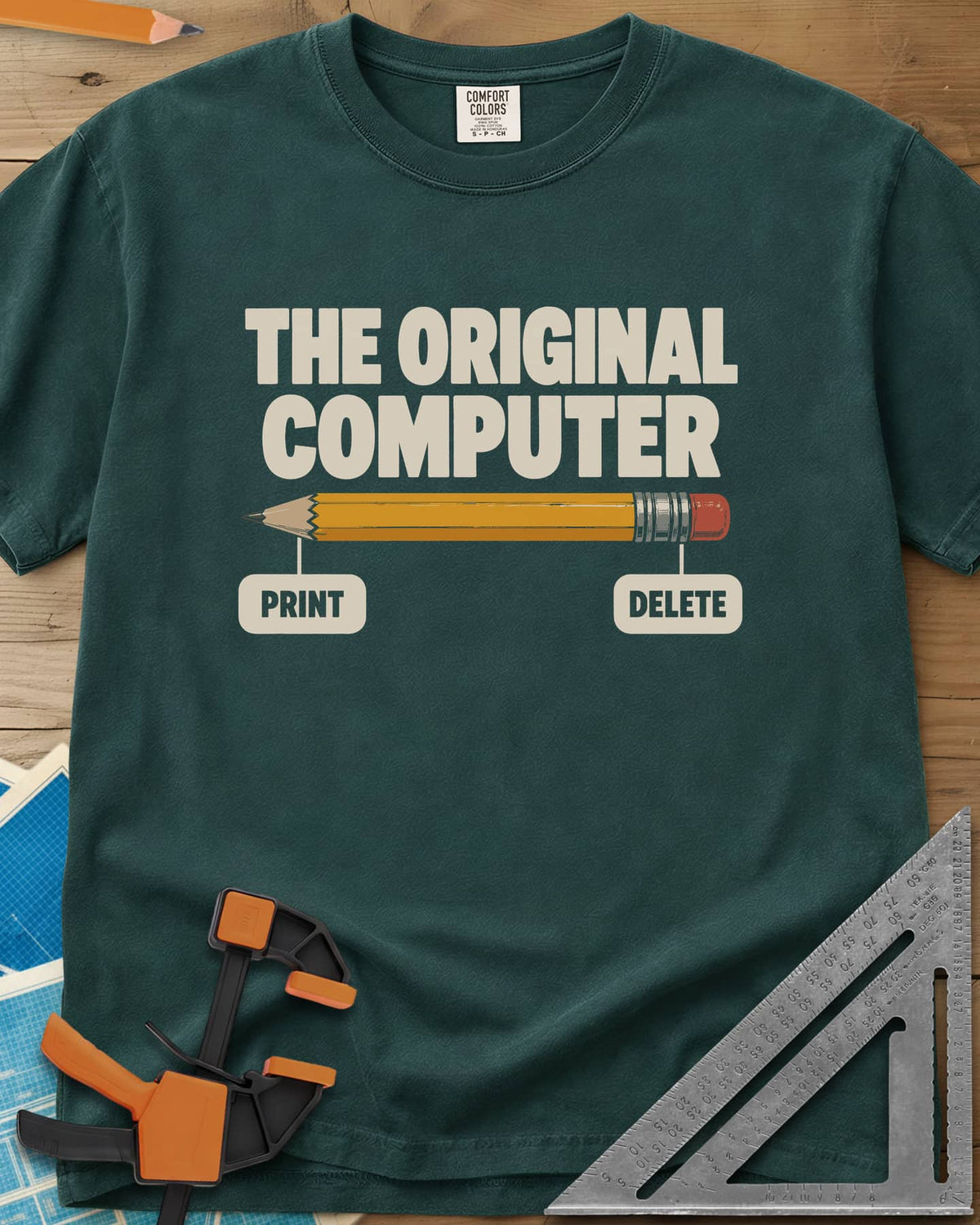 The Original Computer heavyweight tee in Blue Spruce, a yellow pencil labeled PRINT at the point and DELETE at the eraser