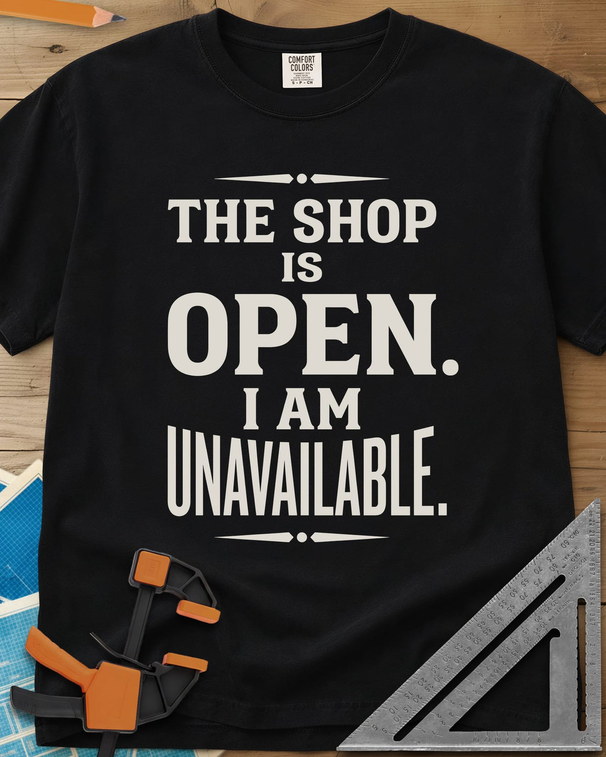 The Shop Is Open I Am Unavailable heavyweight tee in Black, stacked serif lettering between two ornamental dividers