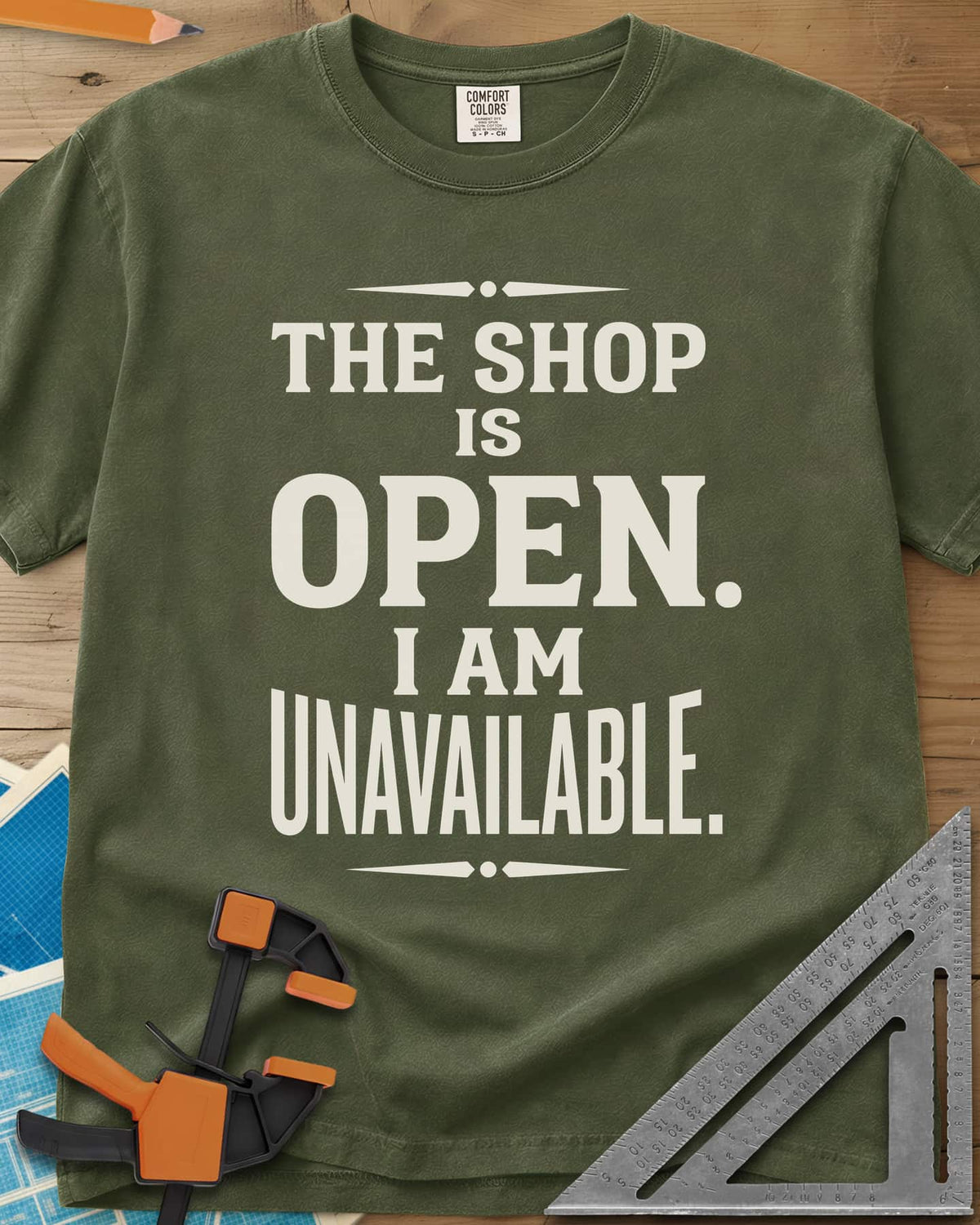 The Shop Is Open I Am Unavailable heavyweight tee in Hemp, stacked serif lettering between two ornamental dividers
