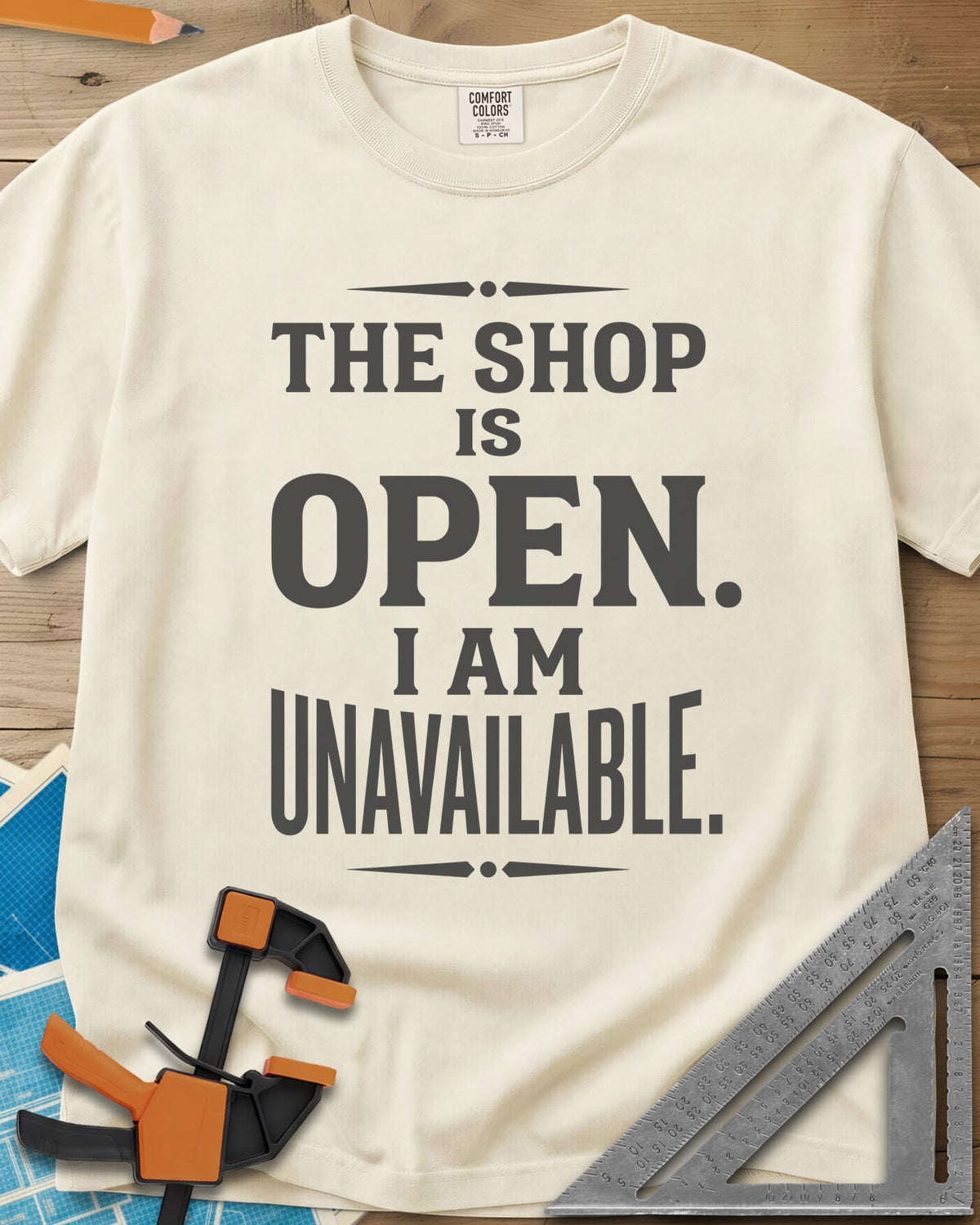 The Shop Is Open I Am Unavailable heavyweight tee in Ivory, stacked serif lettering between two ornamental dividers