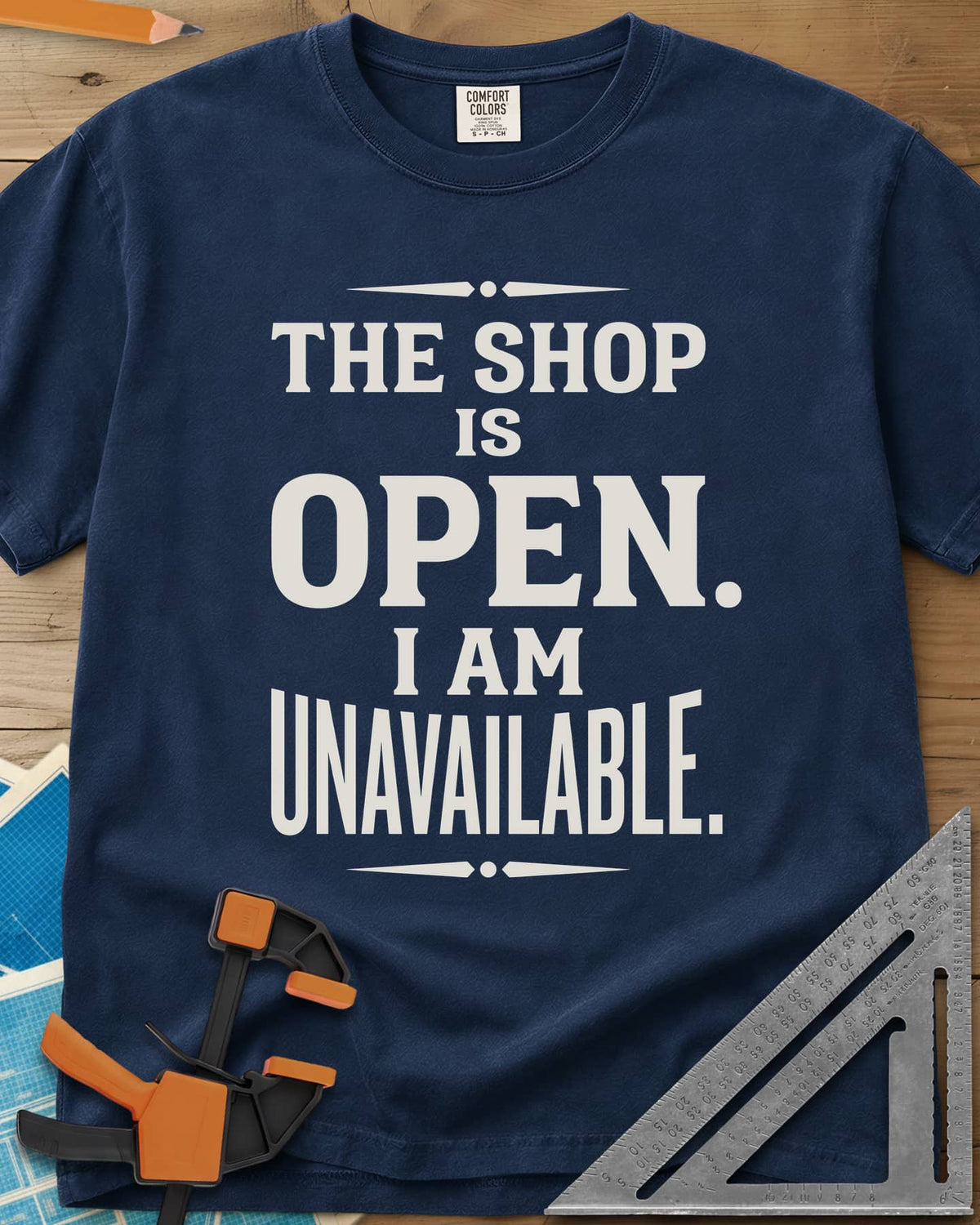 The Shop Is Open I Am Unavailable heavyweight tee in Navy, stacked serif lettering between two ornamental dividers