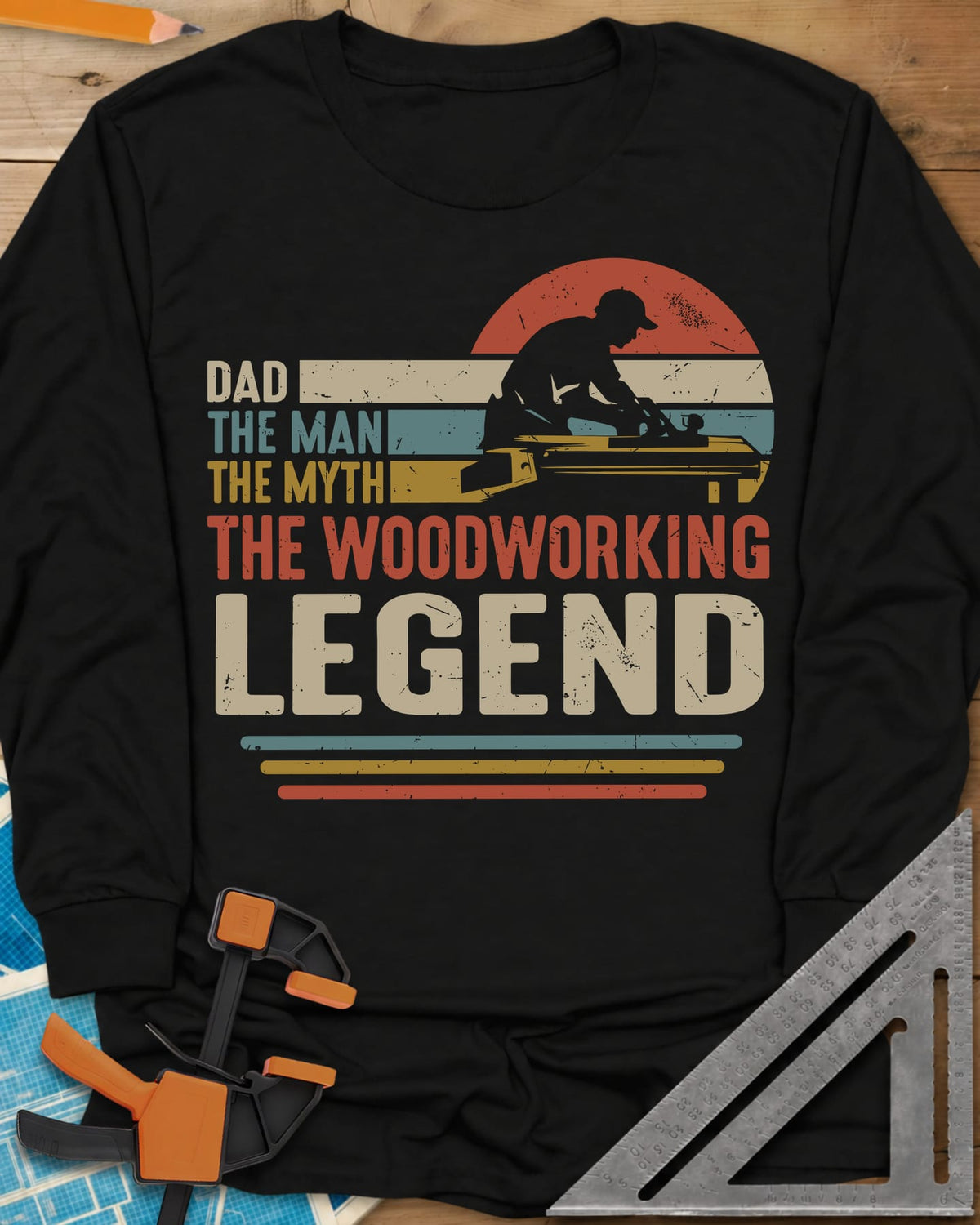 The Woodworking Legend long sleeve shirt in Black, retro sunset stripes behind a silhouetted woodworker at his bench