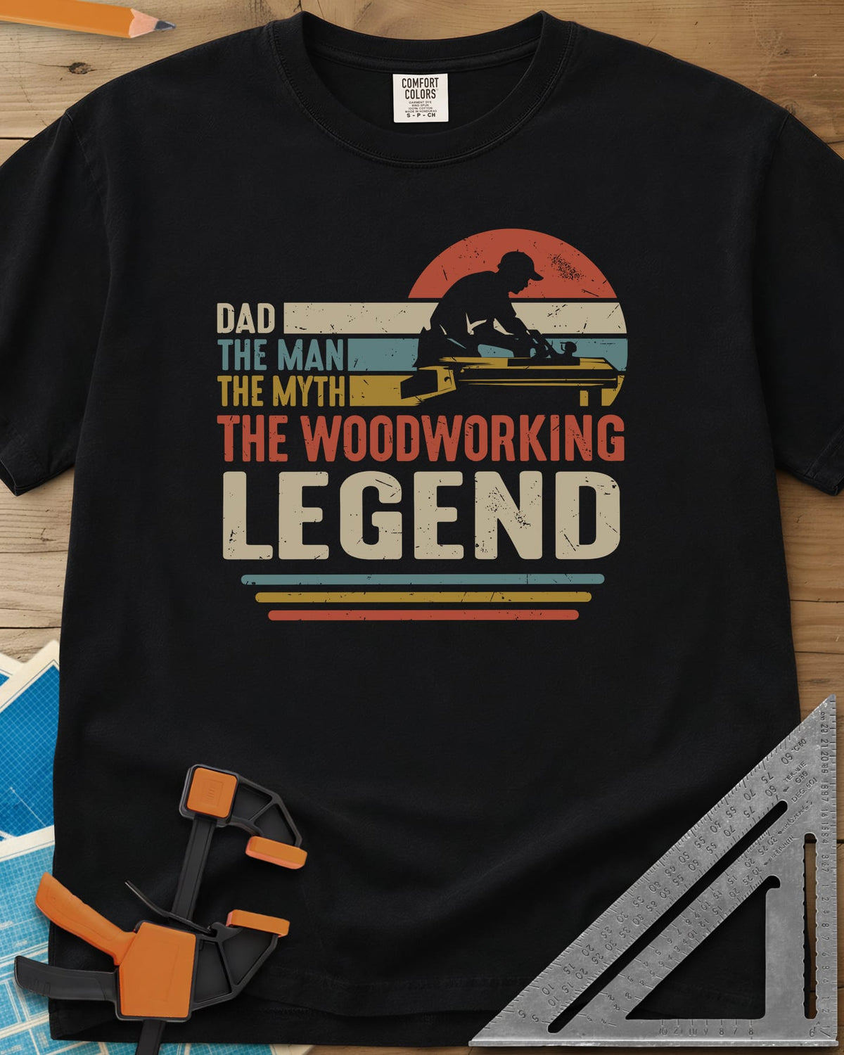 The Woodworking Legend heavyweight tee in Black, retro sunset stripes behind a silhouetted woodworker at his bench