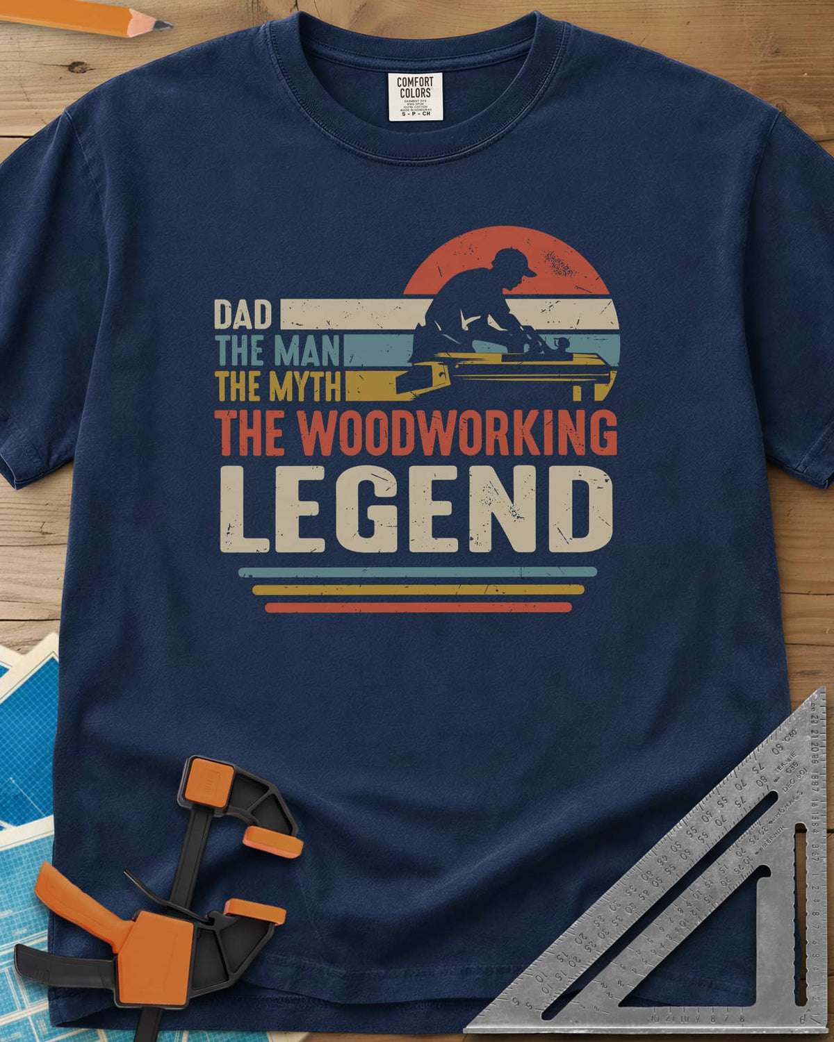 The Woodworking Legend heavyweight tee in Navy, retro sunset stripes behind a silhouetted woodworker at his bench