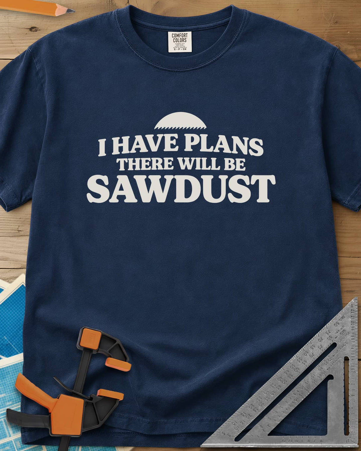 There Will Be Sawdust heavyweight tee in Navy, half a toothed saw blade above rounded, bold lettering