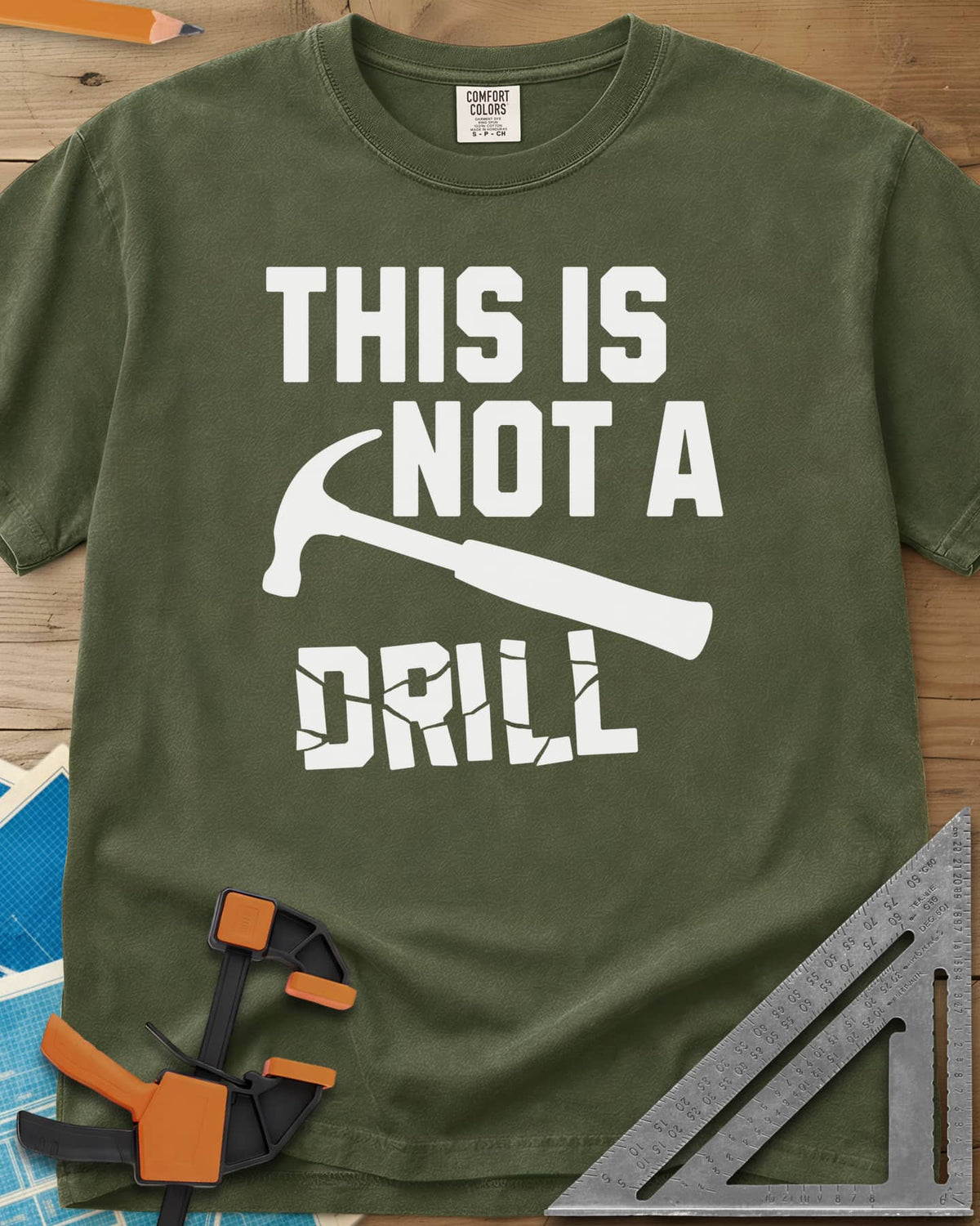This is Not a Drill heavyweight tee in Hemp, a claw hammer across the lettering, with DRILL cracked apart