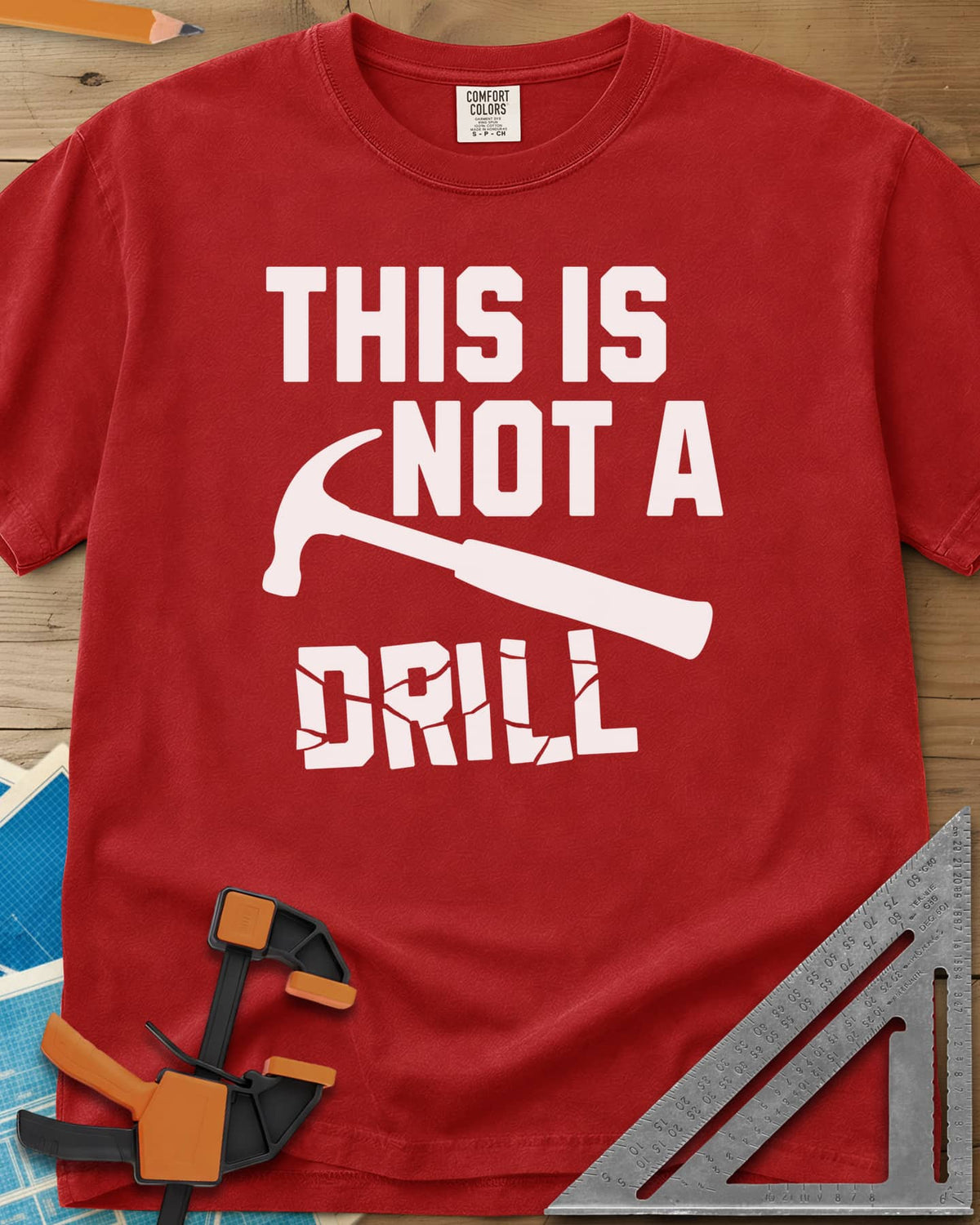 This is Not a Drill heavyweight tee in Red, a claw hammer across the lettering, with DRILL cracked apart
