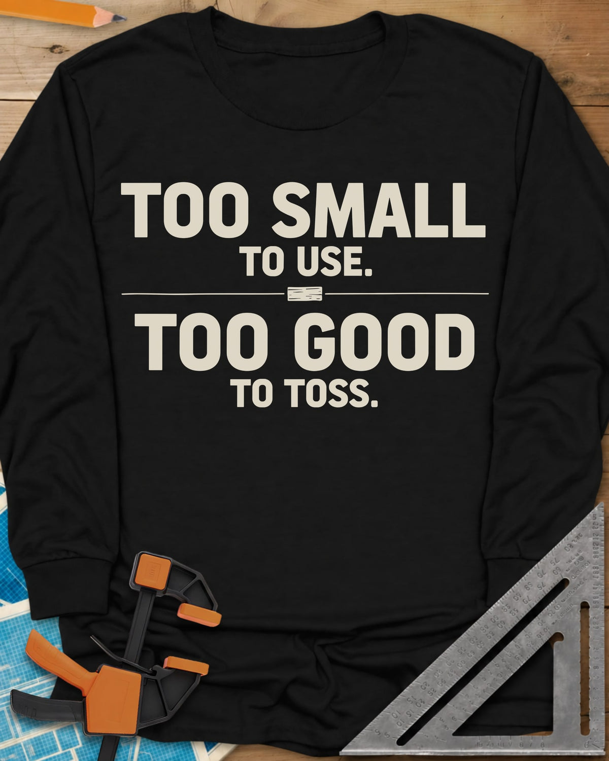 Too Small To Use Too Good To Toss long sleeve shirt in Black, two-line slogan split by a rule with a tiny wood offcut