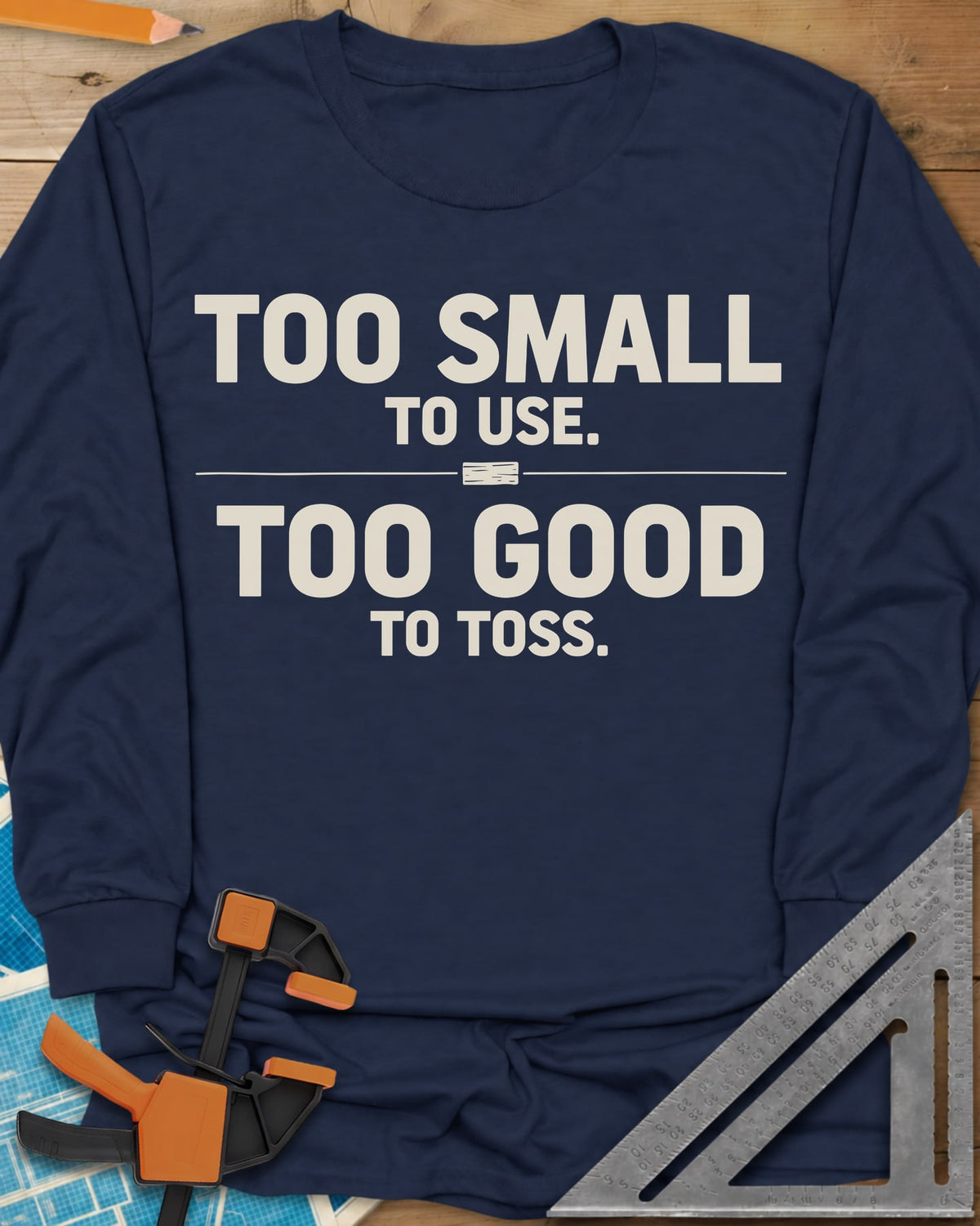 Too Small To Use Too Good To Toss long sleeve shirt in Navy, two-line slogan split by a rule with a tiny wood offcut