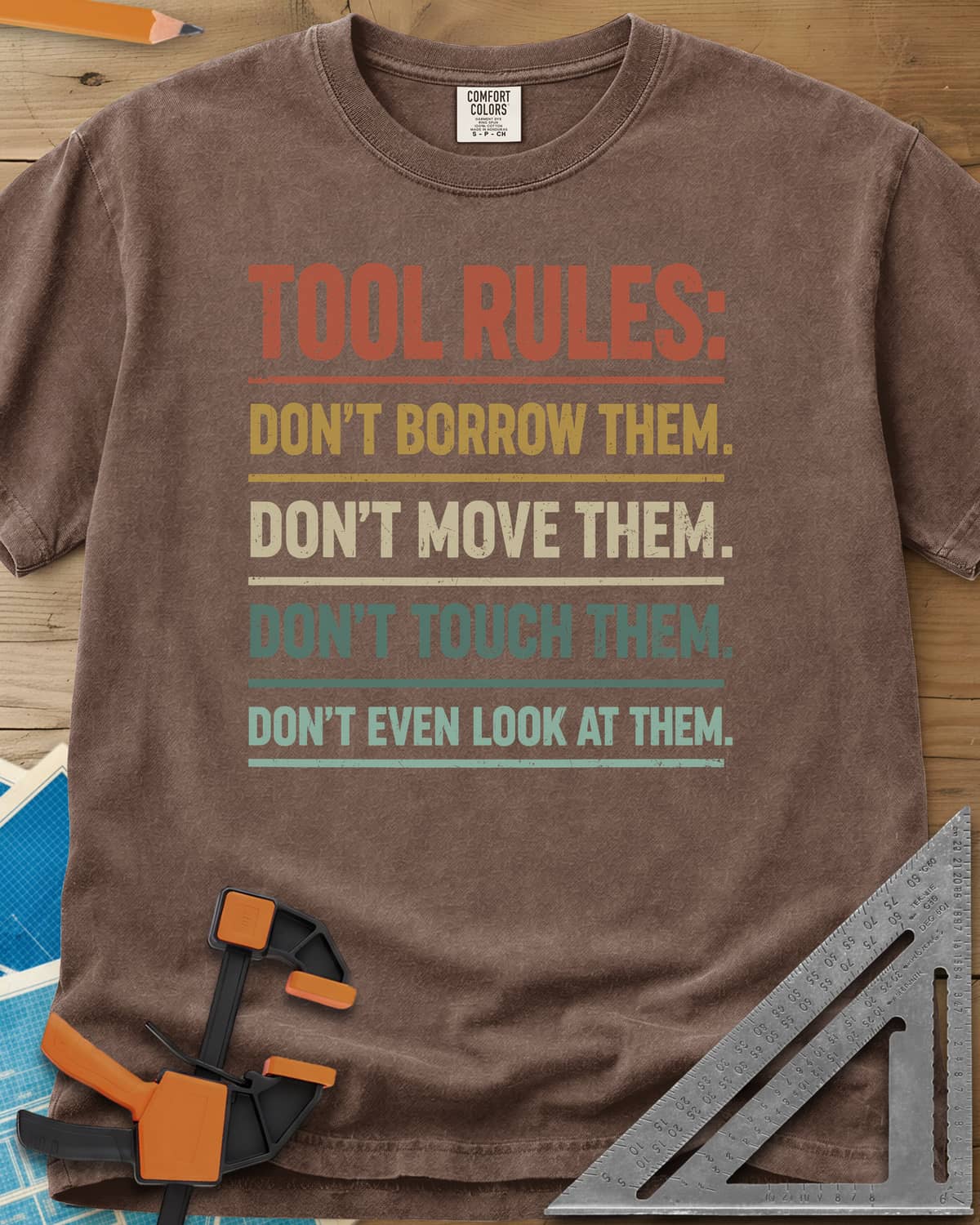Tool Rules heavyweight tee in Espresso, stacked rule lines in rust, mustard, cream and teal with thin dividers