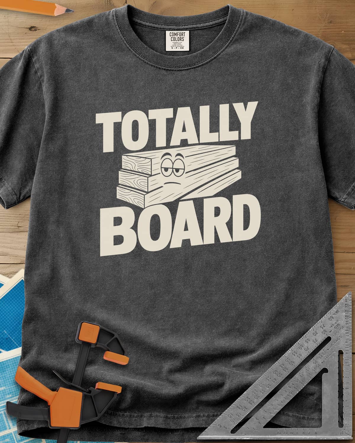 Totally Board heavyweight tee in Pepper, a stack of three planks wearing a bored, half-lidded face