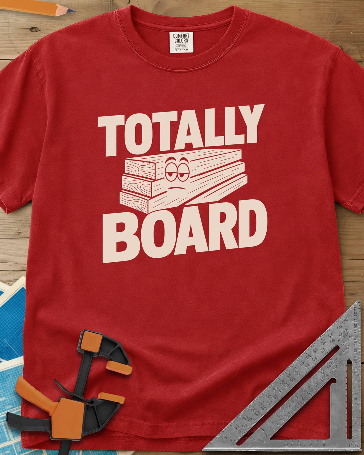 Totally Board heavyweight tee in Red, a stack of three planks wearing a bored, half-lidded face
