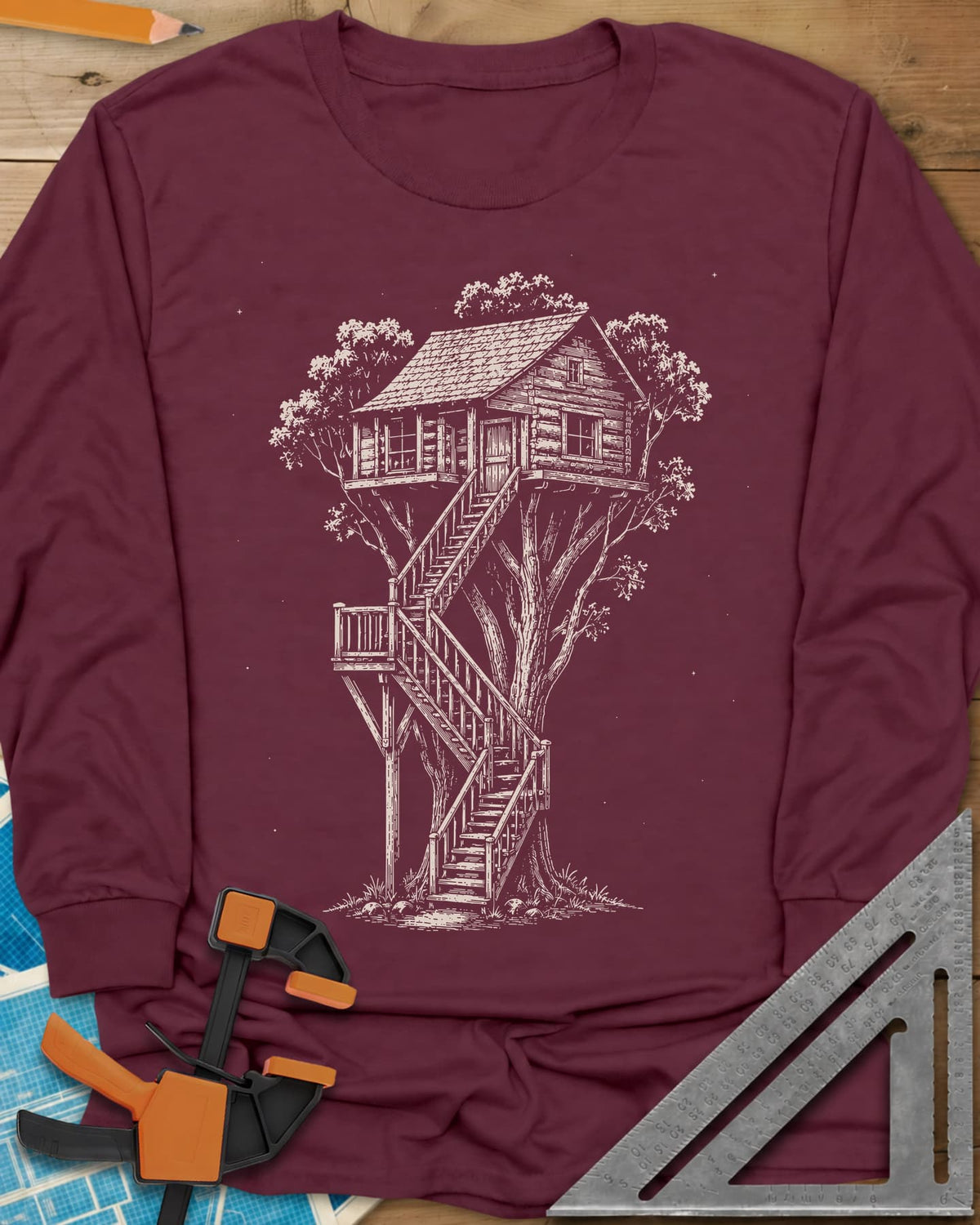 Treehouse Dream Build long sleeve shirt in Maroon, ink-style log cabin treehouse with a zigzag staircase