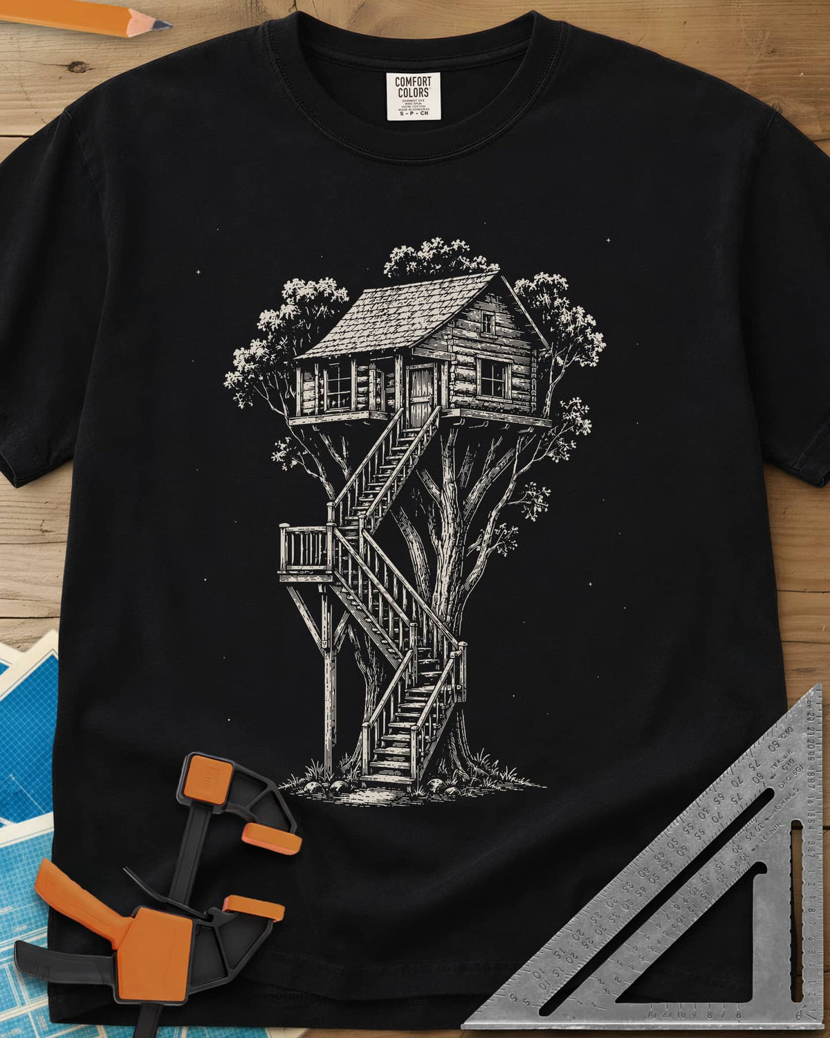Treehouse Dream Build heavyweight tee in Black, ink-style log cabin treehouse with a zigzag staircase