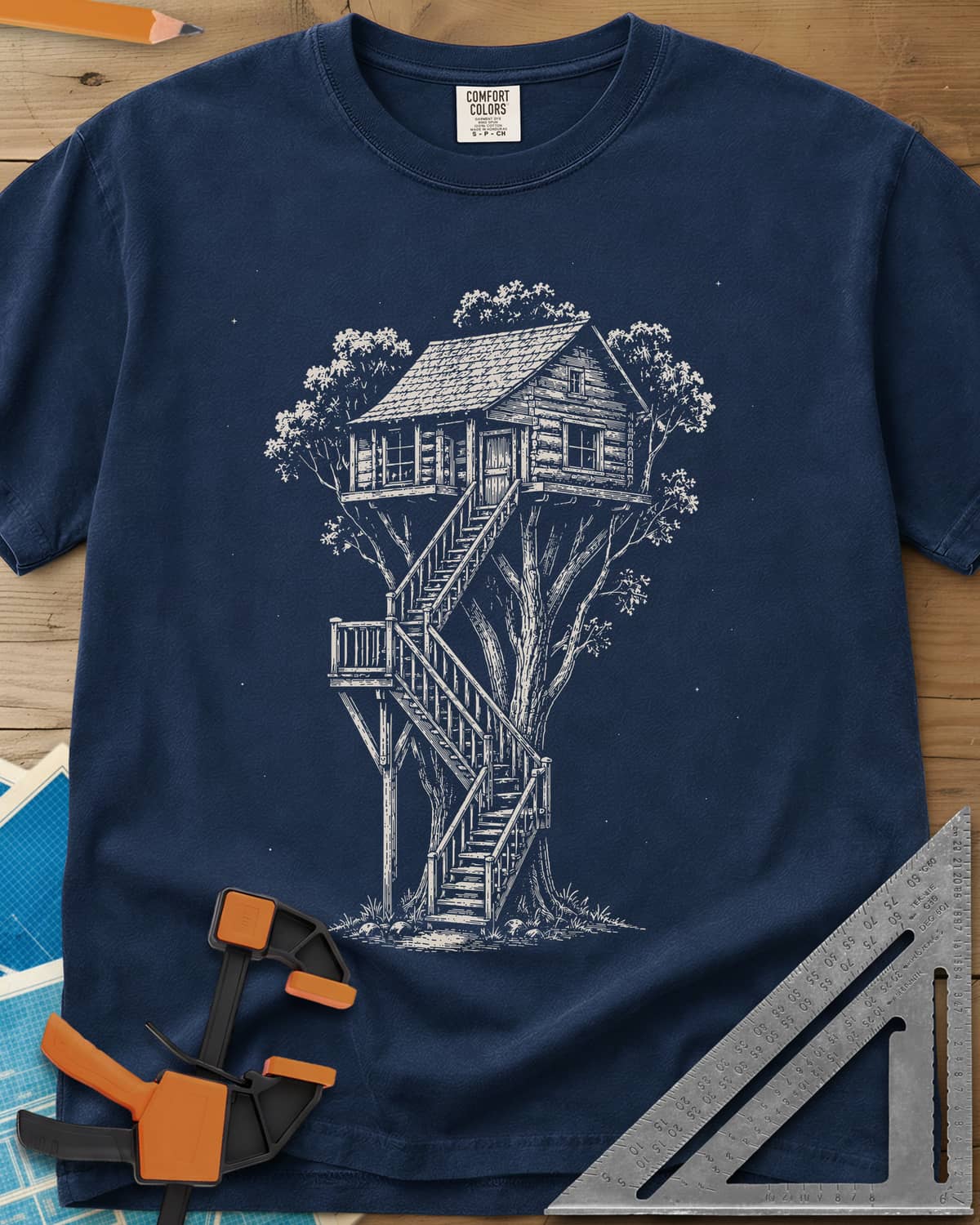 Treehouse Dream Build heavyweight tee in Navy, ink-style log cabin treehouse with a zigzag staircase