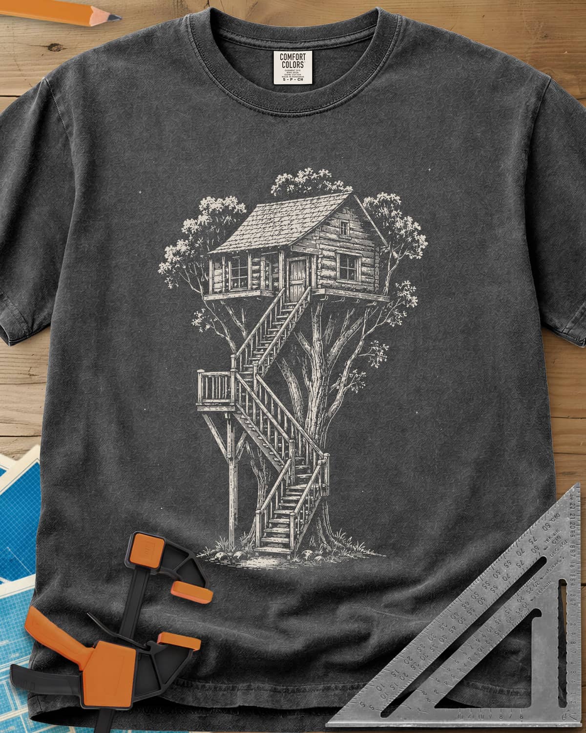 Treehouse Dream Build heavyweight tee in Pepper, ink-style log cabin treehouse with a zigzag staircase