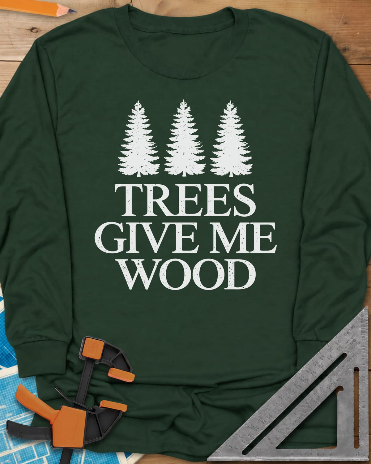 Trees Give Me Wood long sleeve shirt in Forest Green, three evergreen trees above worn serif lettering