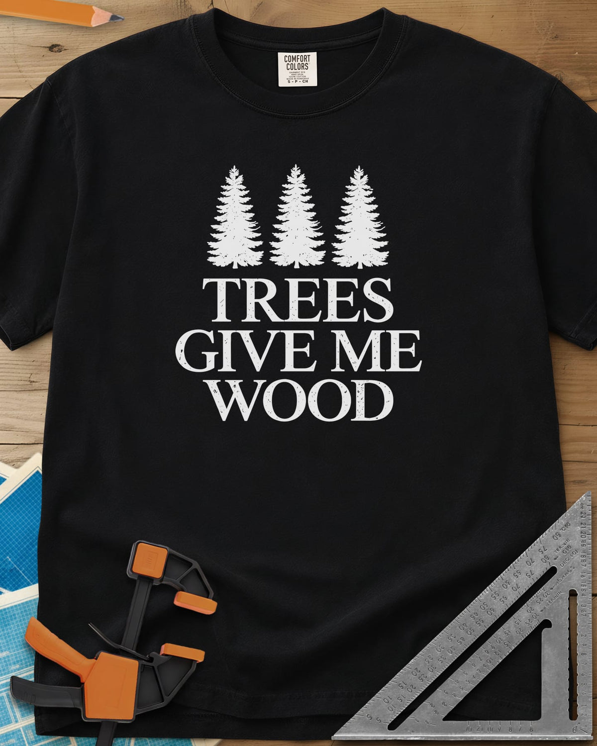 Trees Give Me Wood heavyweight tee in Black, three evergreen trees above worn serif lettering