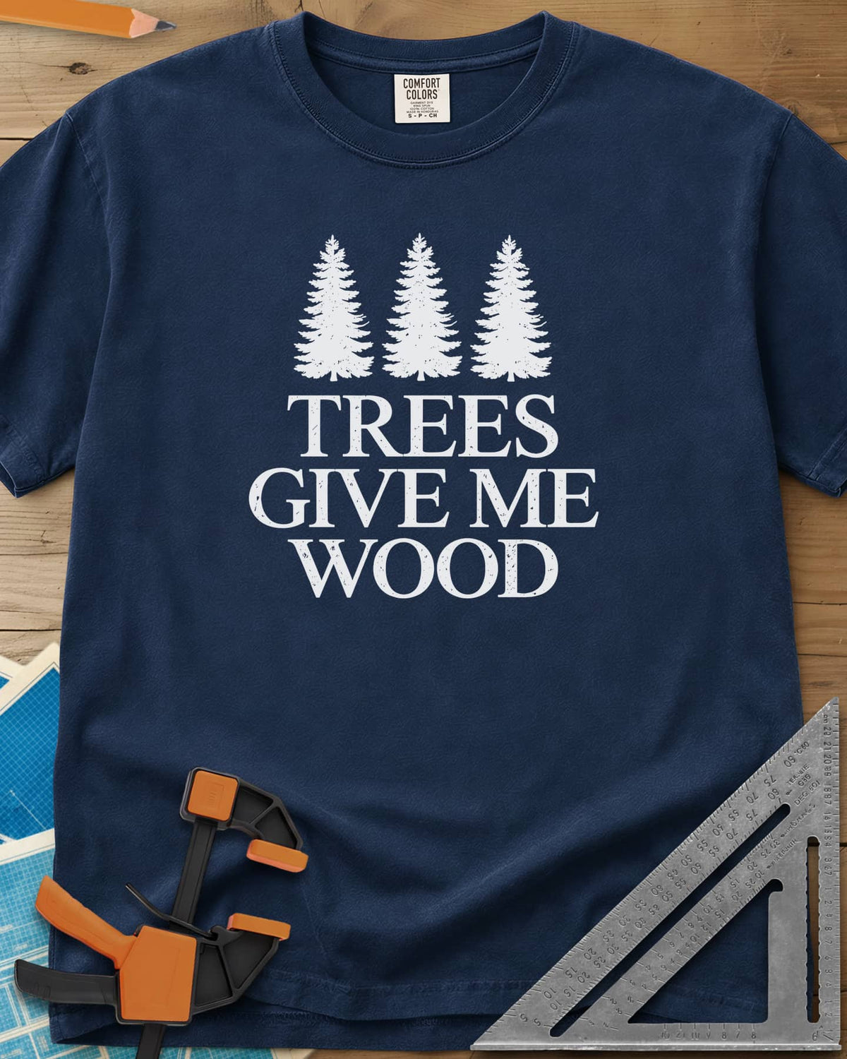 Trees Give Me Wood heavyweight tee in Navy, three evergreen trees above worn serif lettering