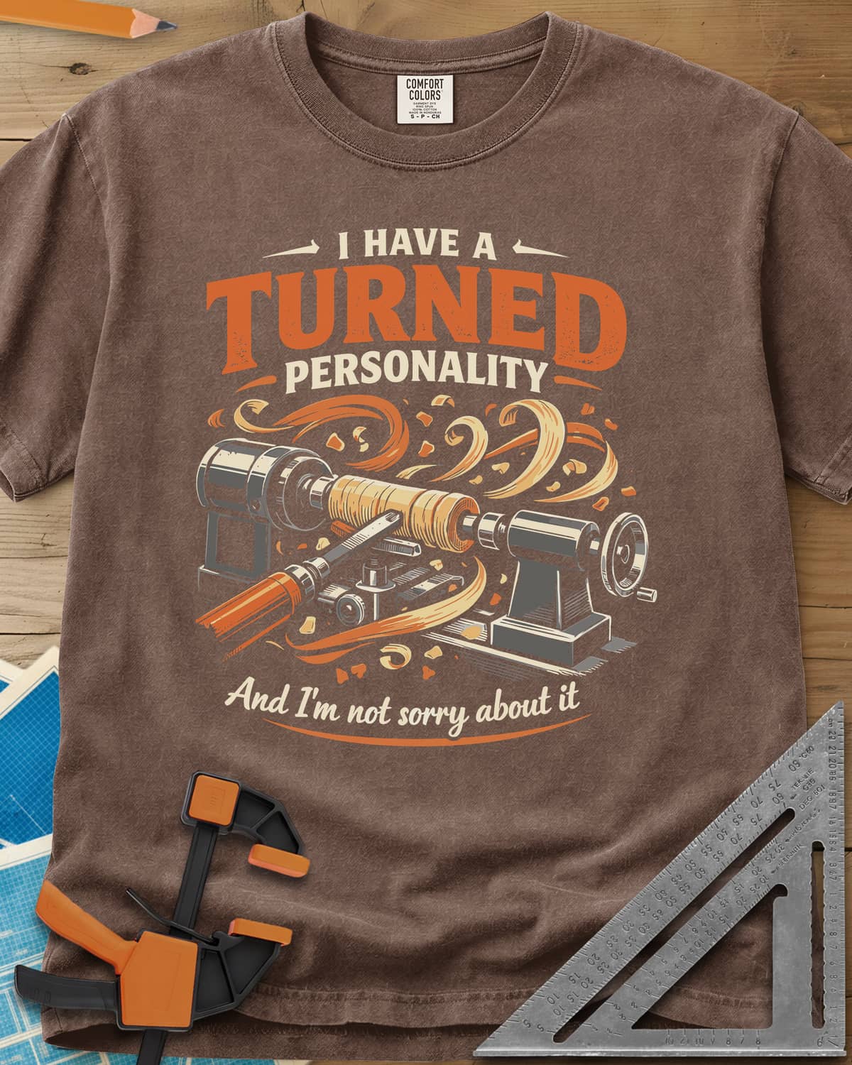 Turned Personality heavyweight tee in Espresso, a wood lathe spinning a blank in a spray of orange shavings