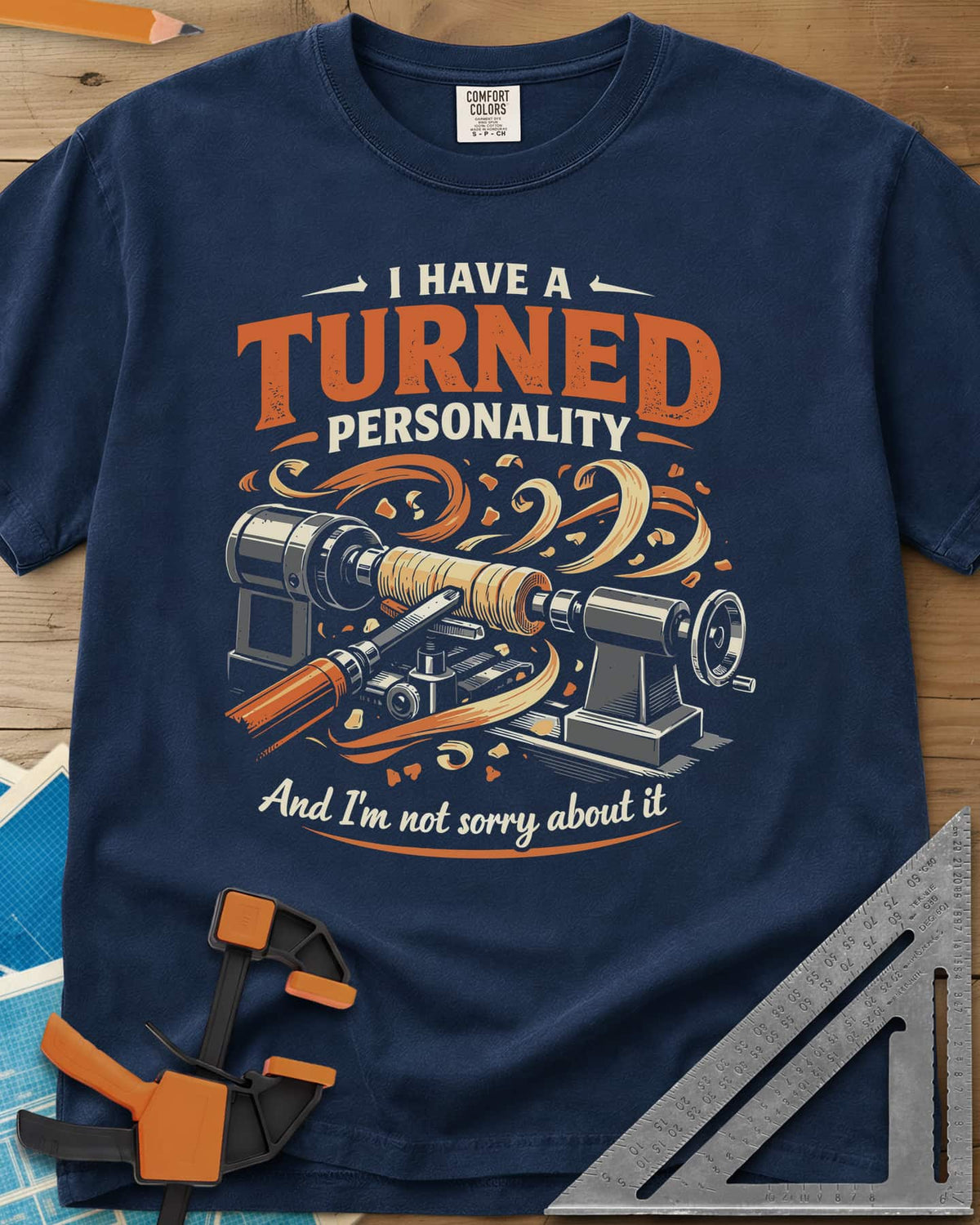 Turned Personality heavyweight tee in Navy, a wood lathe spinning a blank in a spray of orange shavings