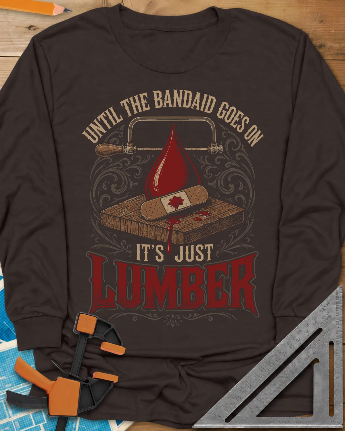 Until The Bandaid Goes On It's Just Lumber long sleeve shirt in Dark Chocolate, frame saw, red drop and a bandaid on a board