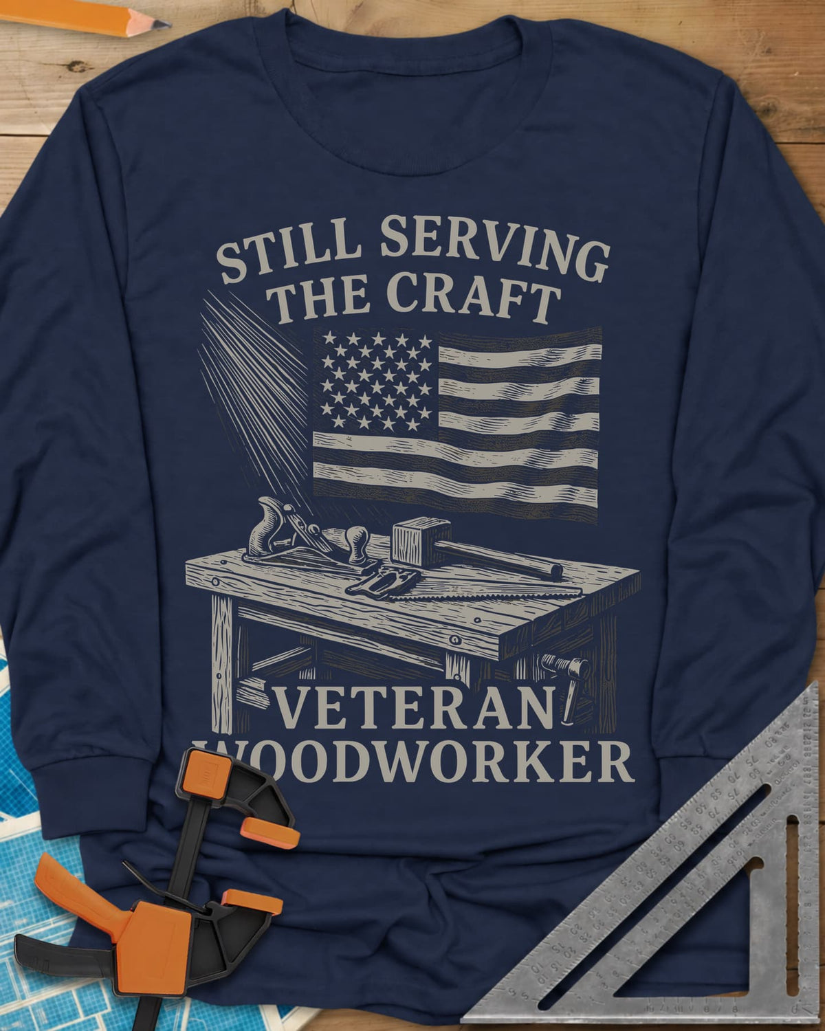 Veteran Woodworker long sleeve shirt in Navy, an American flag over a workbench with a plane, mallet and saw