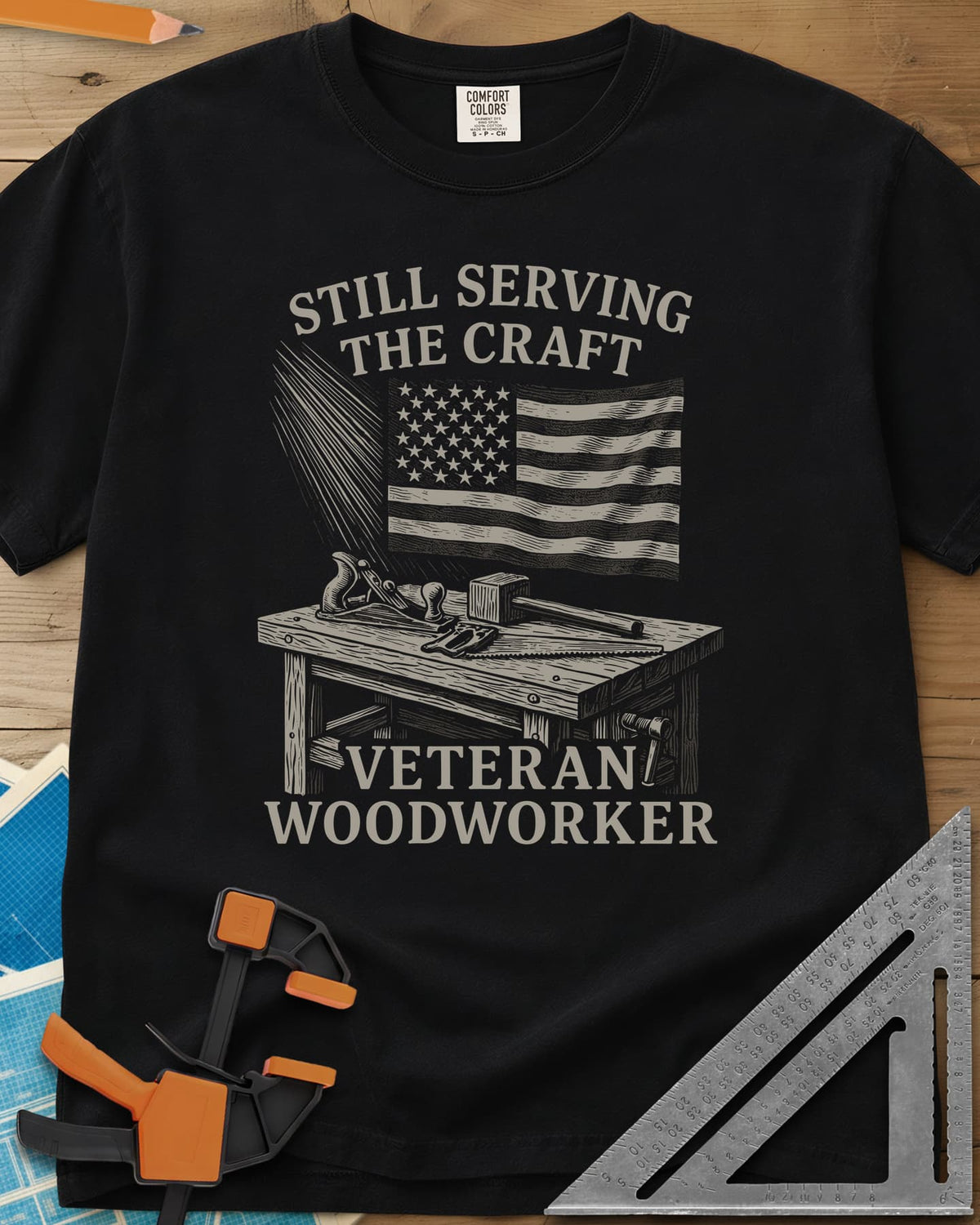 Veteran Woodworker heavyweight tee in Black, an American flag over a workbench with a plane, mallet and saw