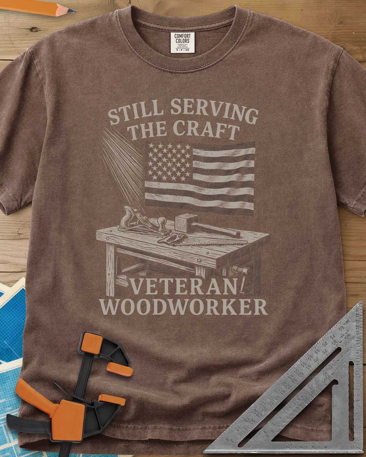 Veteran Woodworker heavyweight tee in Espresso, an American flag over a workbench with a plane, mallet and saw
