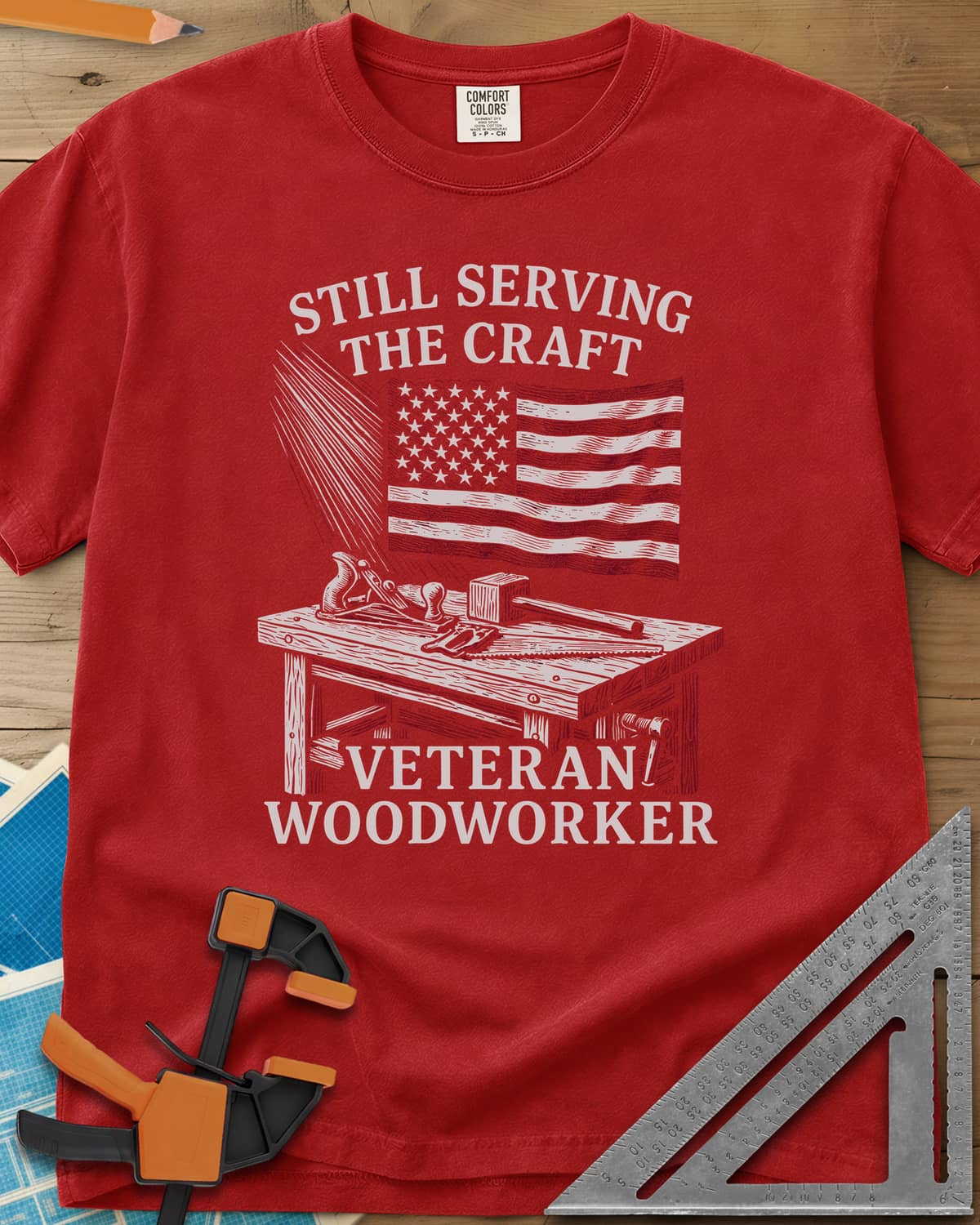 Veteran Woodworker heavyweight tee in Red, an American flag over a workbench with a plane, mallet and saw