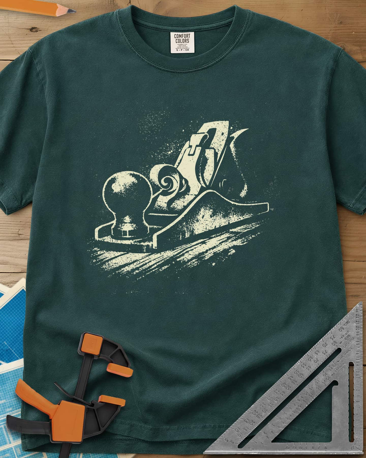 Vintage Hand Plane heavyweight tee in Blue Spruce, a speckled hand plane with a shaving curl on grained wood