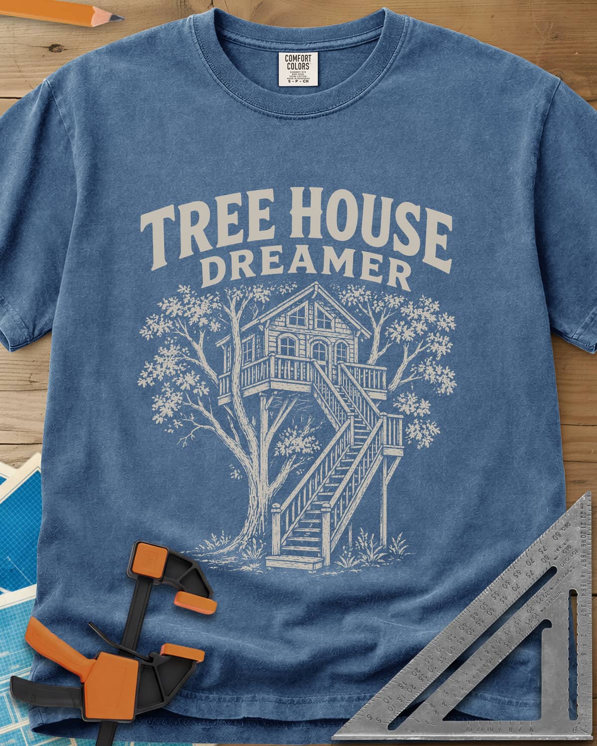 Vintage Tree House Dreamer heavyweight tee in Blue Jean, engraved-style treehouse with a railed deck and wide stairs