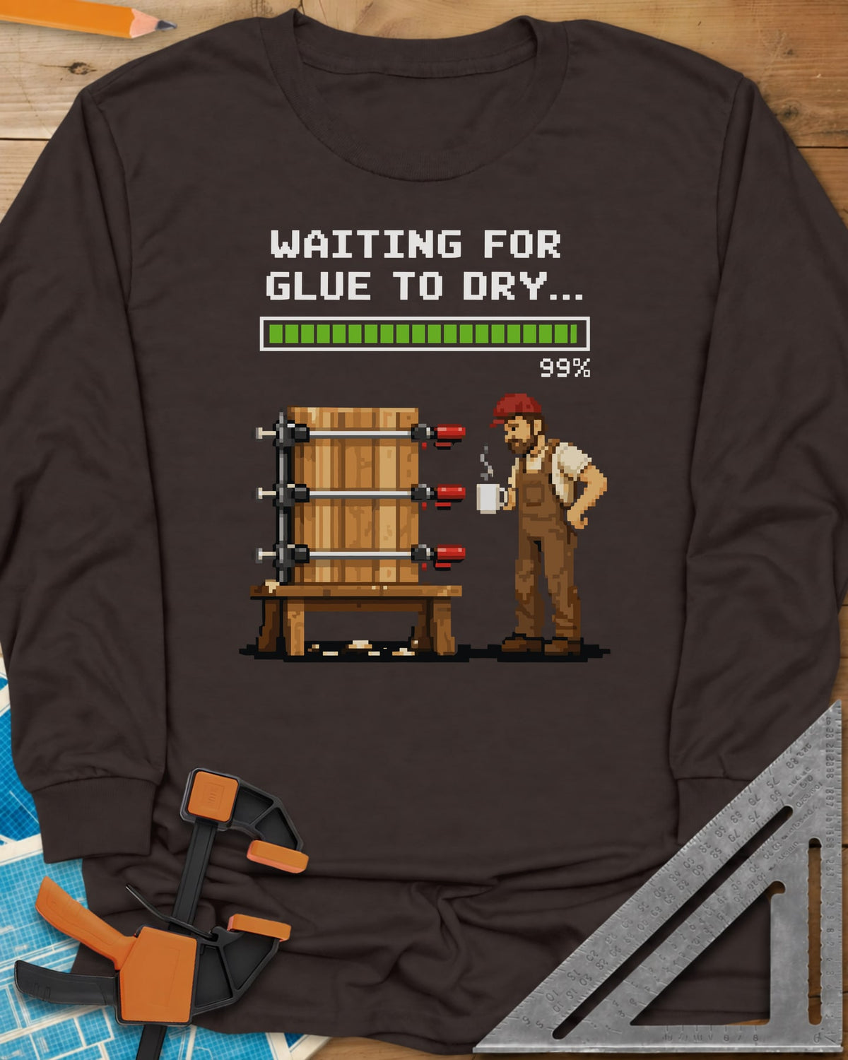 Waiting For Glue To Dry long sleeve shirt in Dark Chocolate, pixel-art woodworker with a coffee mug beside a clamped glue-up