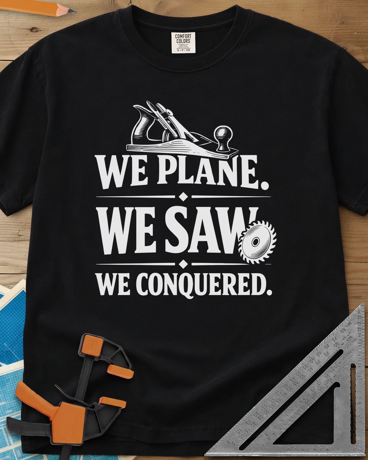 We Plane, We Saw heavyweight tee in Black, a hand plane and a saw blade framing a three-line slogan
