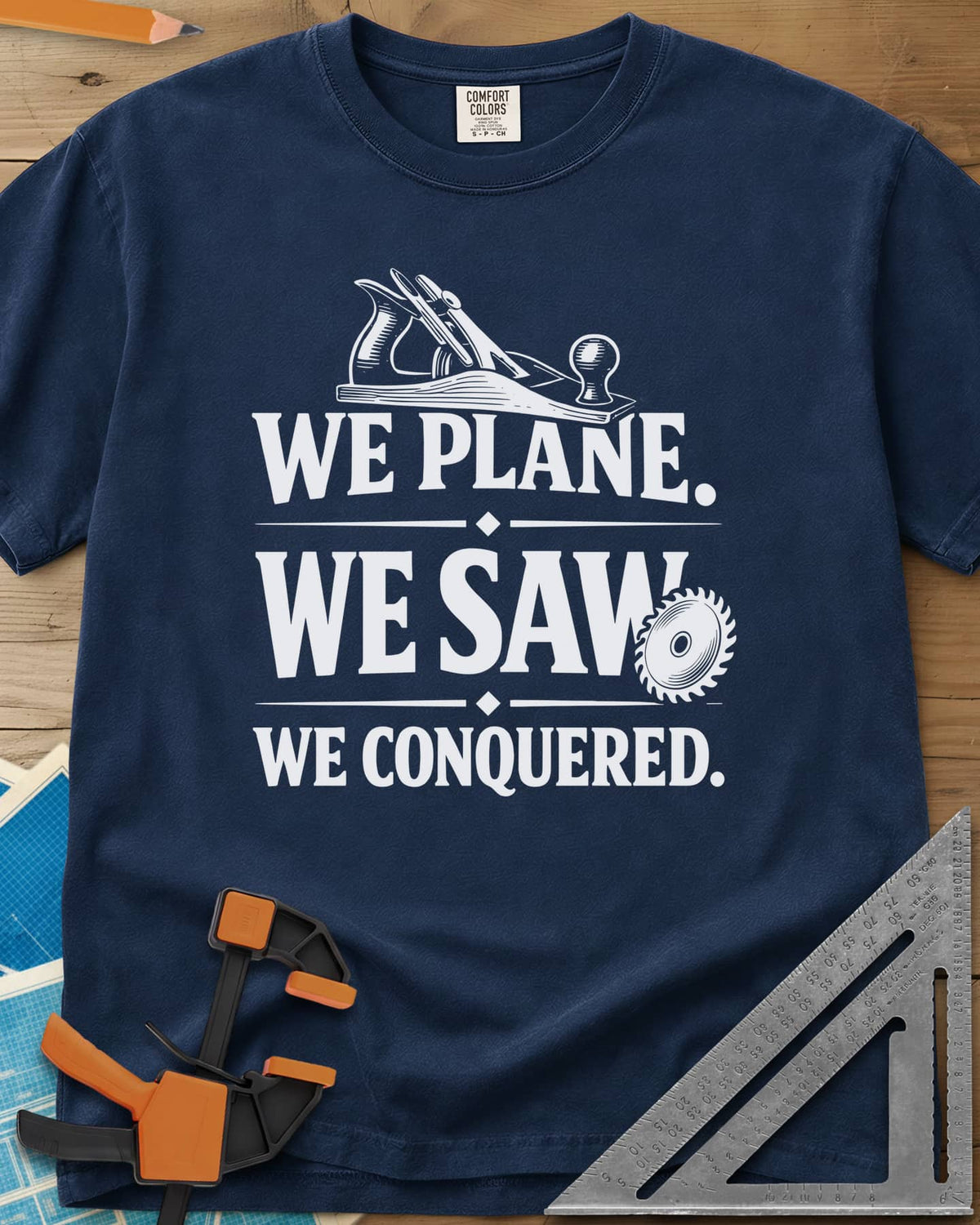 We Plane, We Saw heavyweight tee in Navy, a hand plane and a saw blade framing a three-line slogan