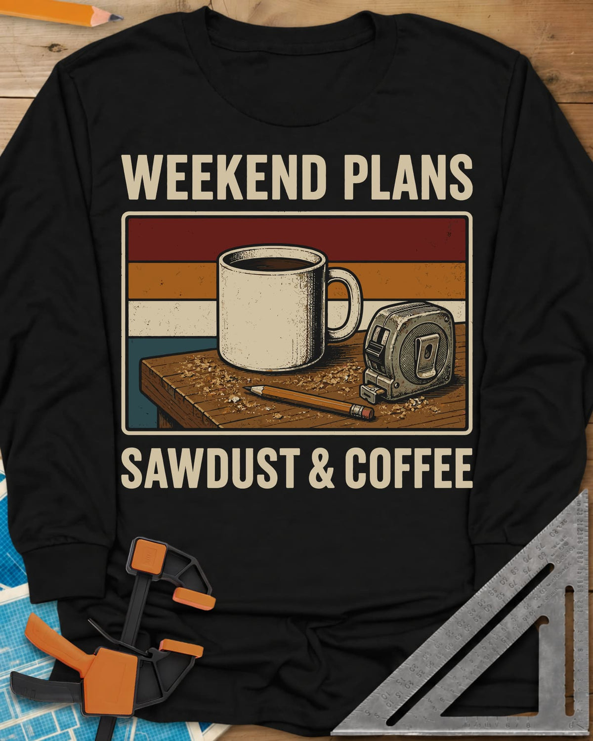 Weekend Plans Sawdust Coffee long sleeve shirt in Black, a coffee mug, tape measure and pencil on a sawdusty bench
