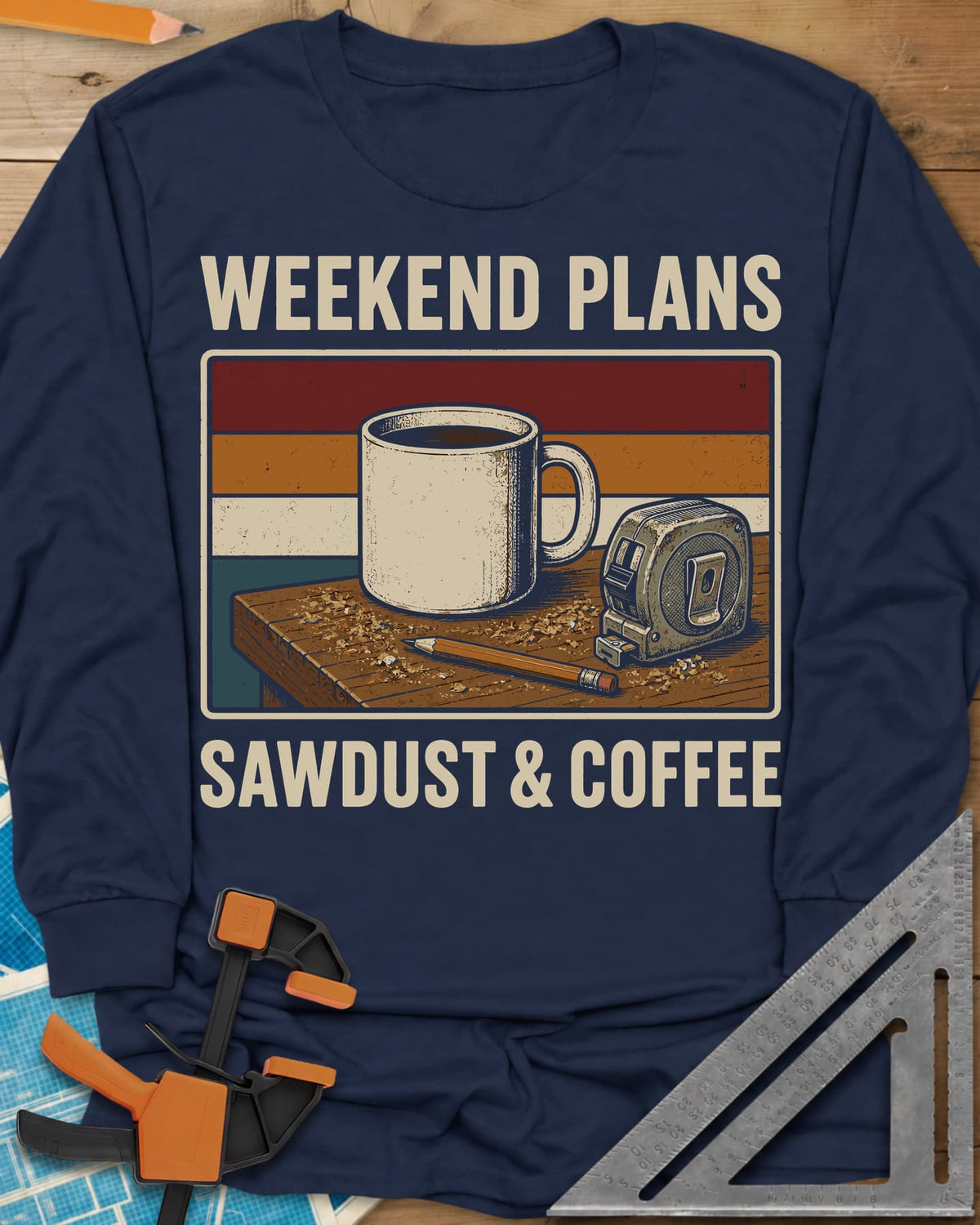 Weekend Plans Sawdust Coffee long sleeve shirt in Navy, a coffee mug, tape measure and pencil on a sawdusty bench