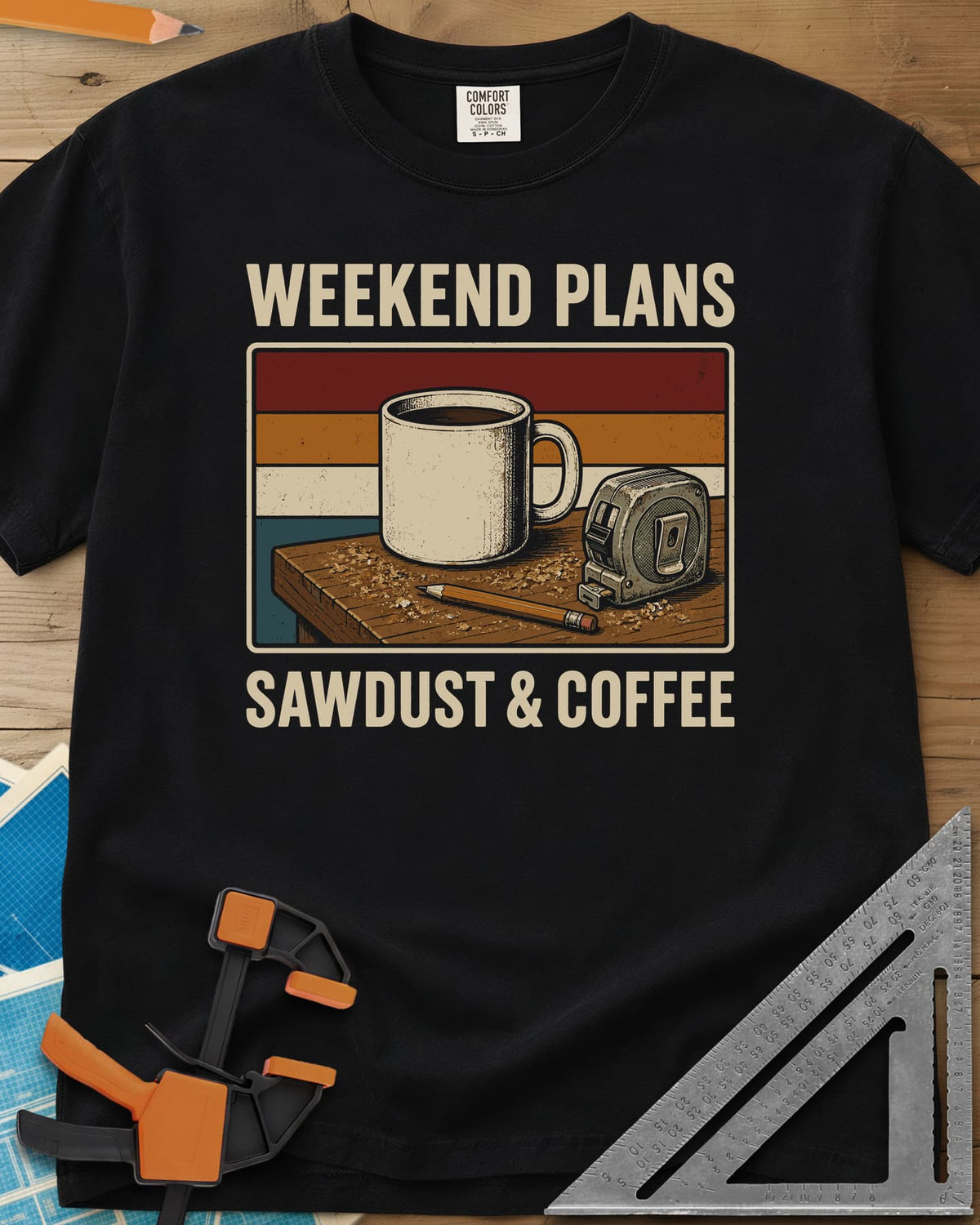 Weekend Plans Sawdust Coffee heavyweight tee in Black, a coffee mug, tape measure and pencil on a sawdusty bench