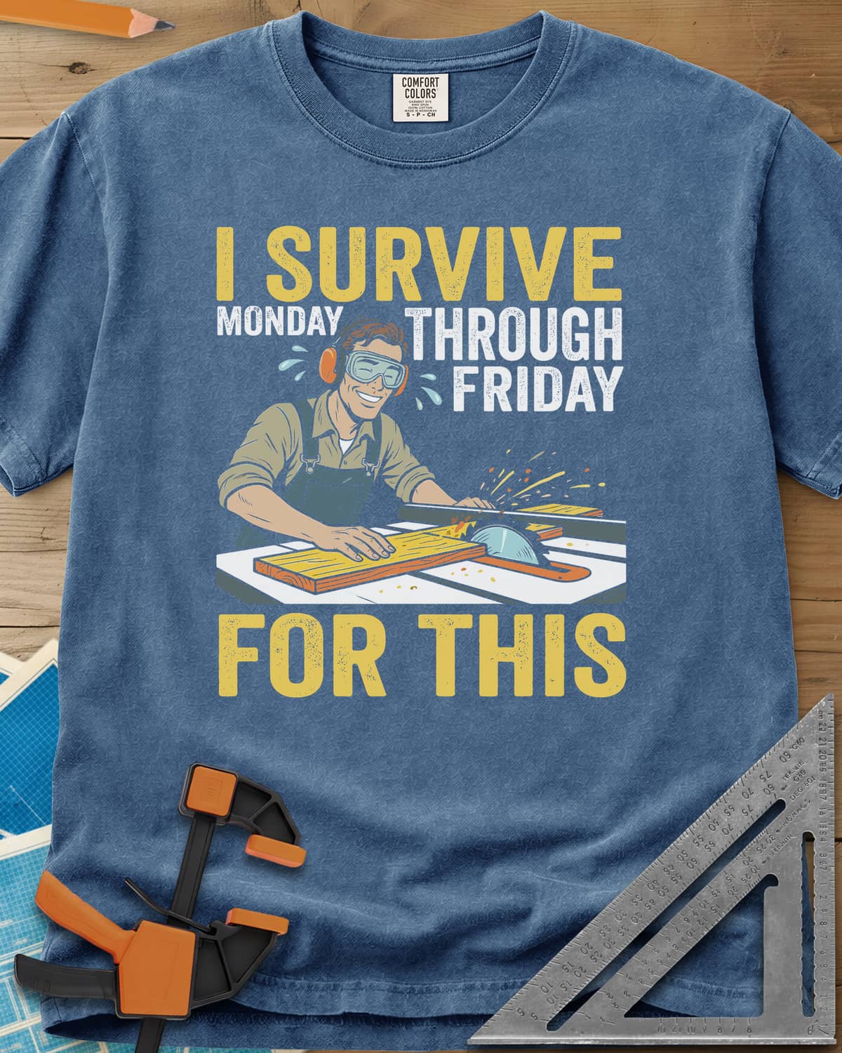 Weekend Reward heavyweight tee in Blue Jean, a smiling woodworker in goggles pushing a board through a table saw