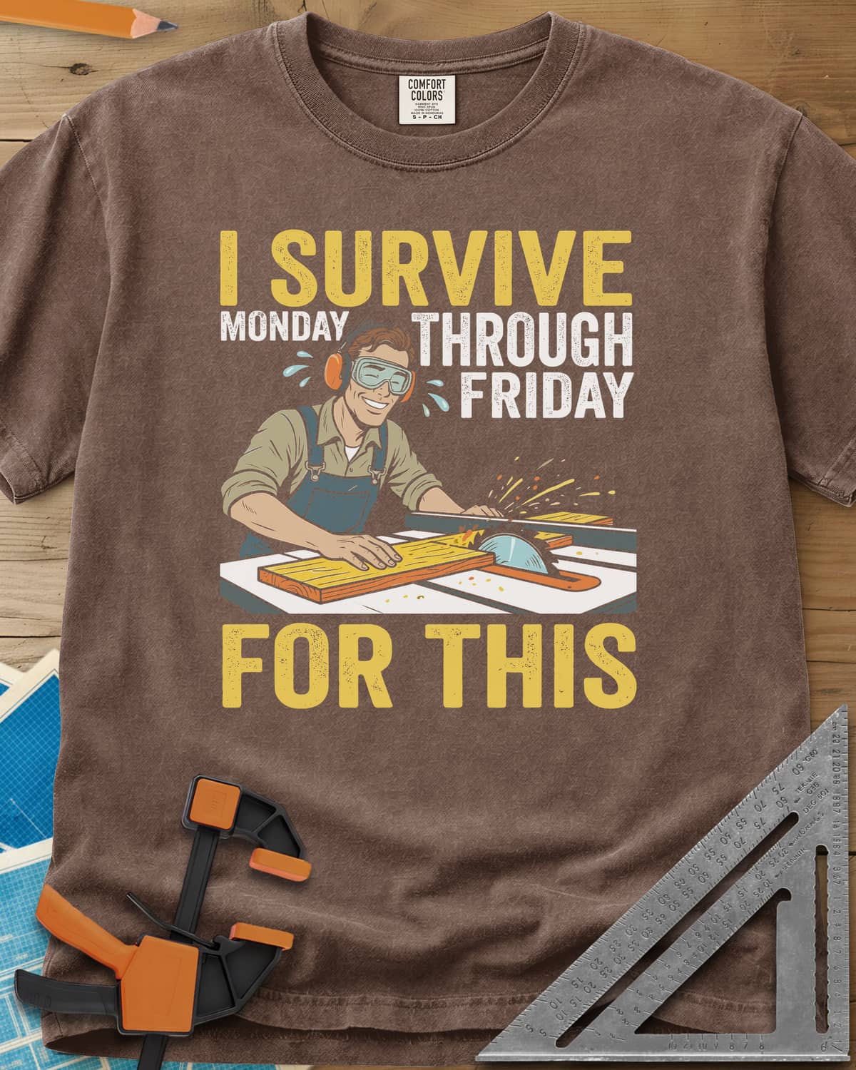 Weekend Reward heavyweight tee in Espresso, a smiling woodworker in goggles pushing a board through a table saw