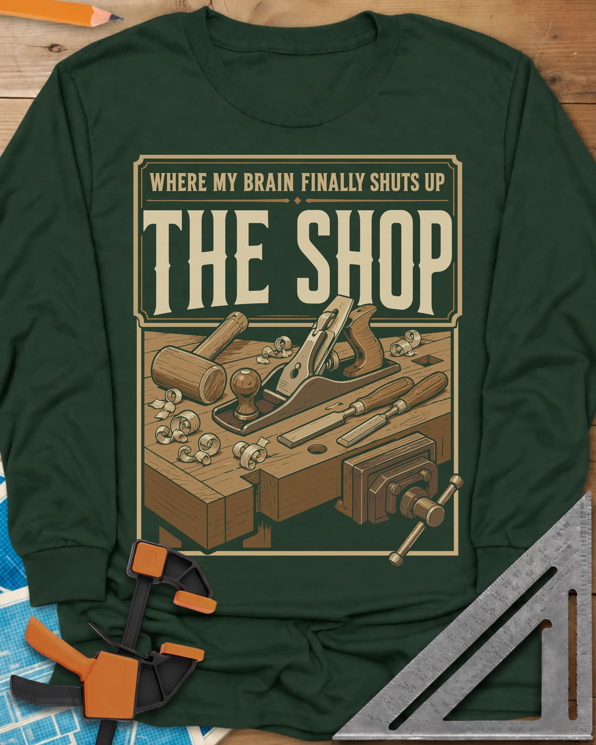 Where My Brain Finally Shuts Up long sleeve shirt in Forest Green, a framed workbench poster with plane, mallet, chisels and