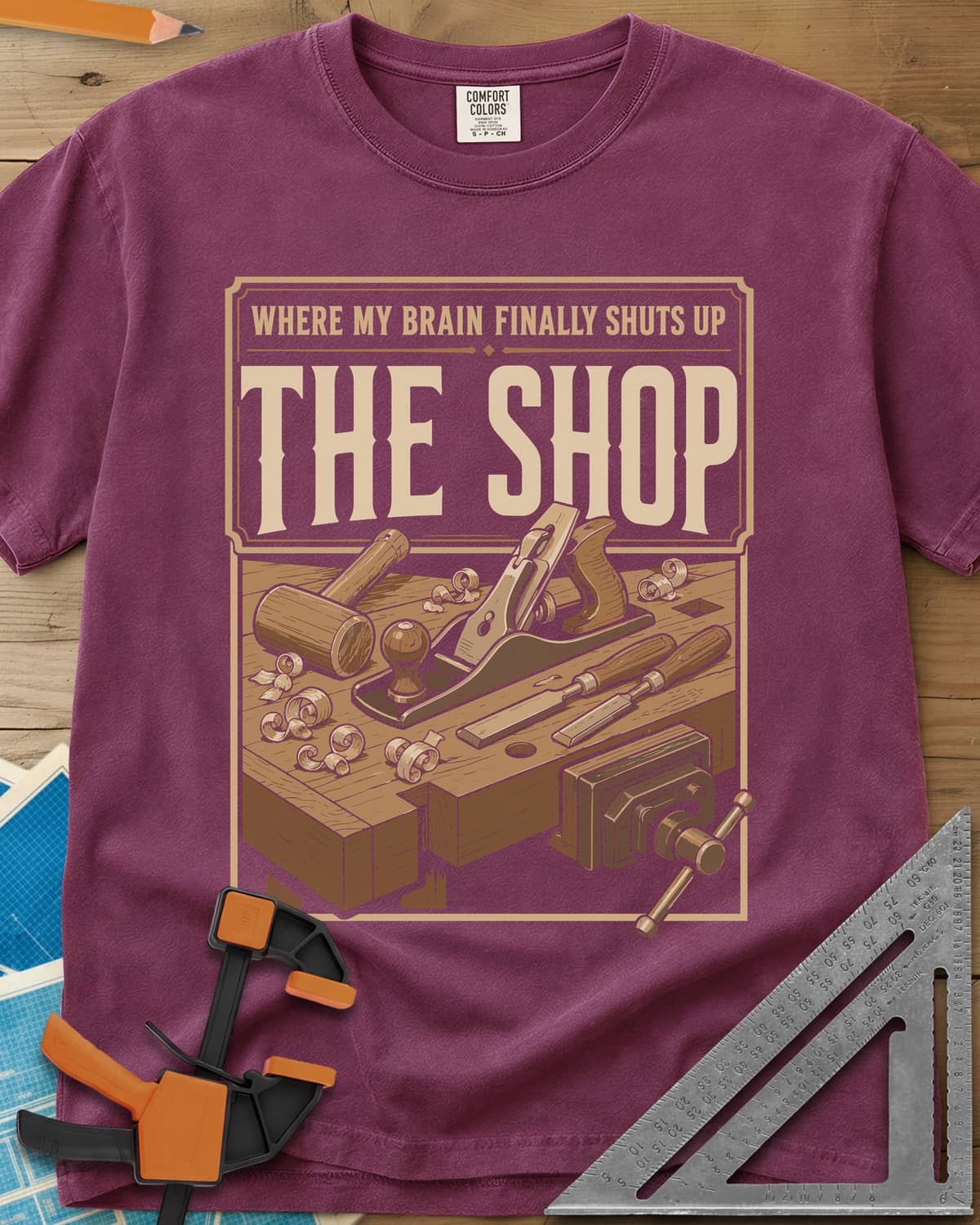Where My Brain Finally Shuts Up heavyweight tee in Berry, a framed workbench poster with plane, mallet, chisels and vise