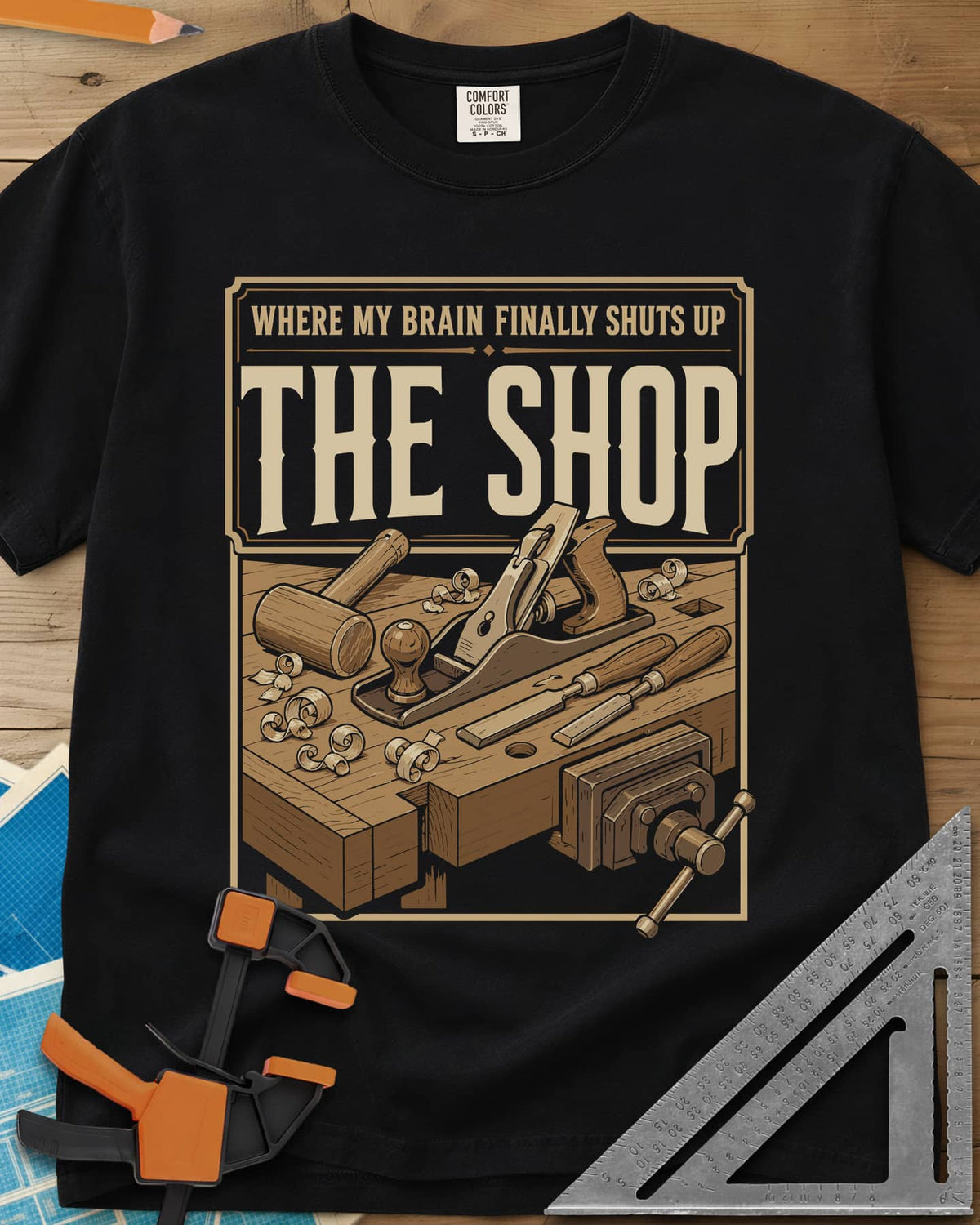 Where My Brain Finally Shuts Up heavyweight tee in Black, a framed workbench poster with plane, mallet, chisels and vise