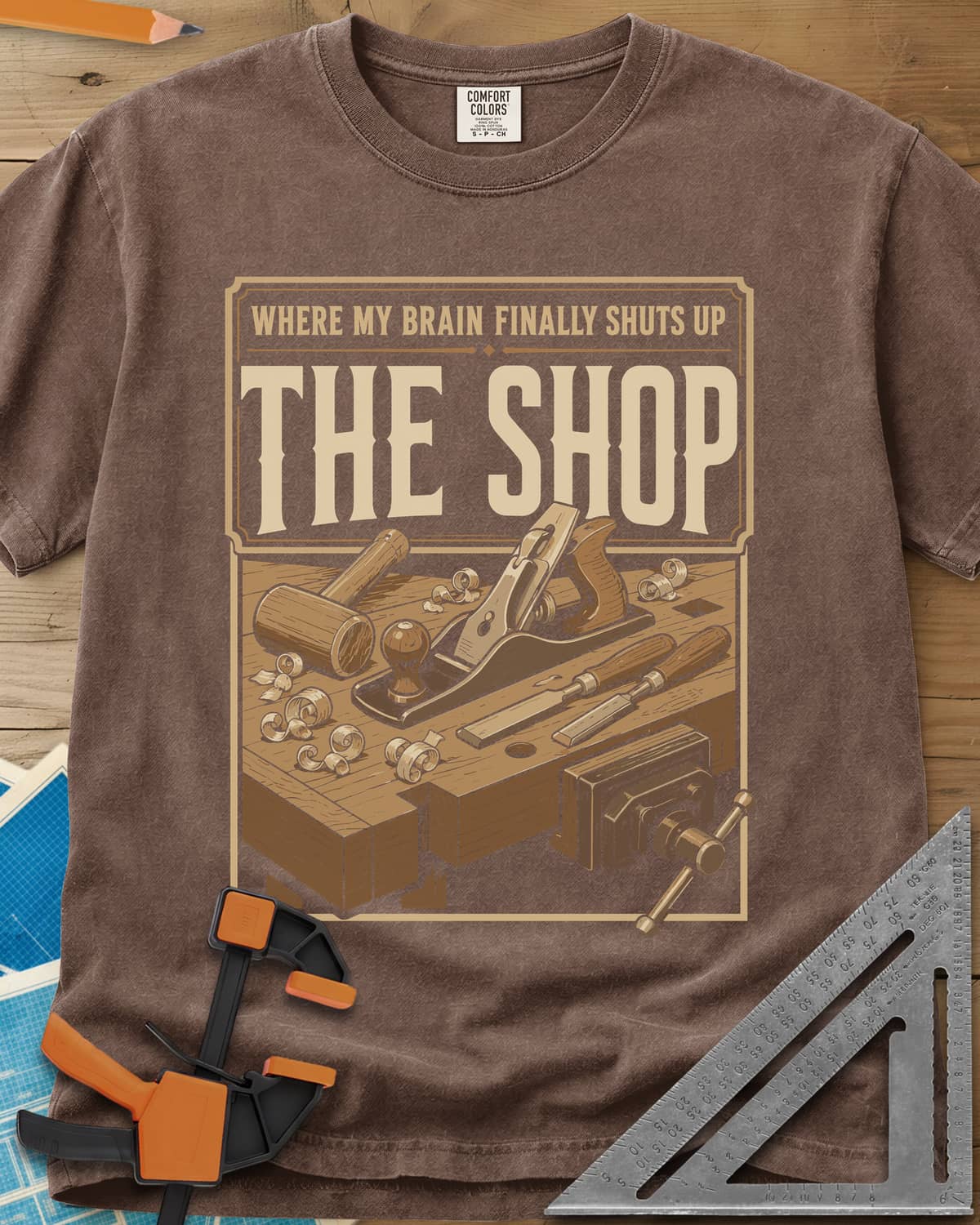 Where My Brain Finally Shuts Up heavyweight tee in Espresso, a framed workbench poster with plane, mallet, chisels and vise