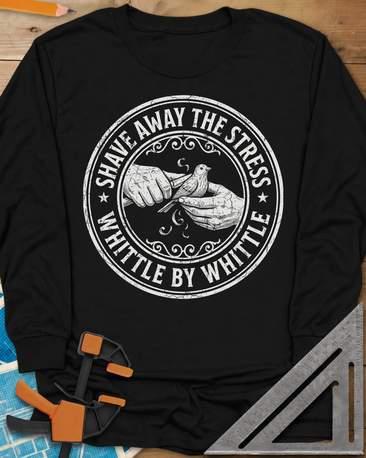 Whittle by Whittle long sleeve shirt in Black, two hands whittling a small bird inside a round distressed badge
