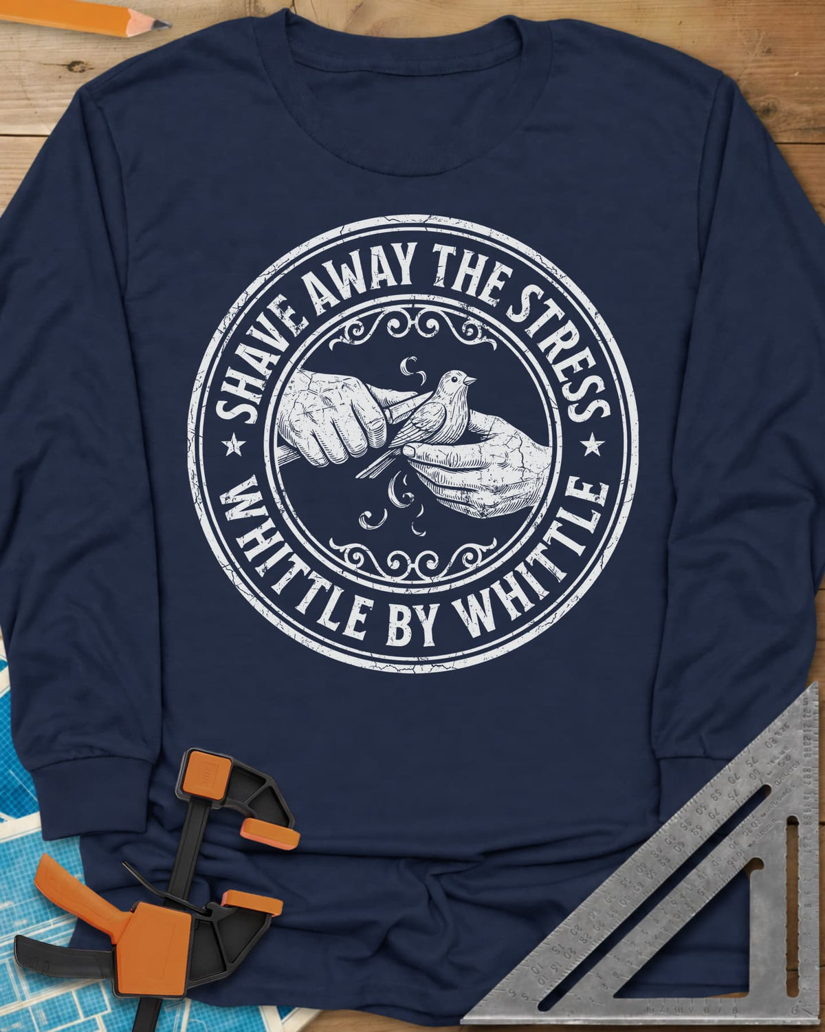 Whittle by Whittle long sleeve shirt in Navy, two hands whittling a small bird inside a round distressed badge