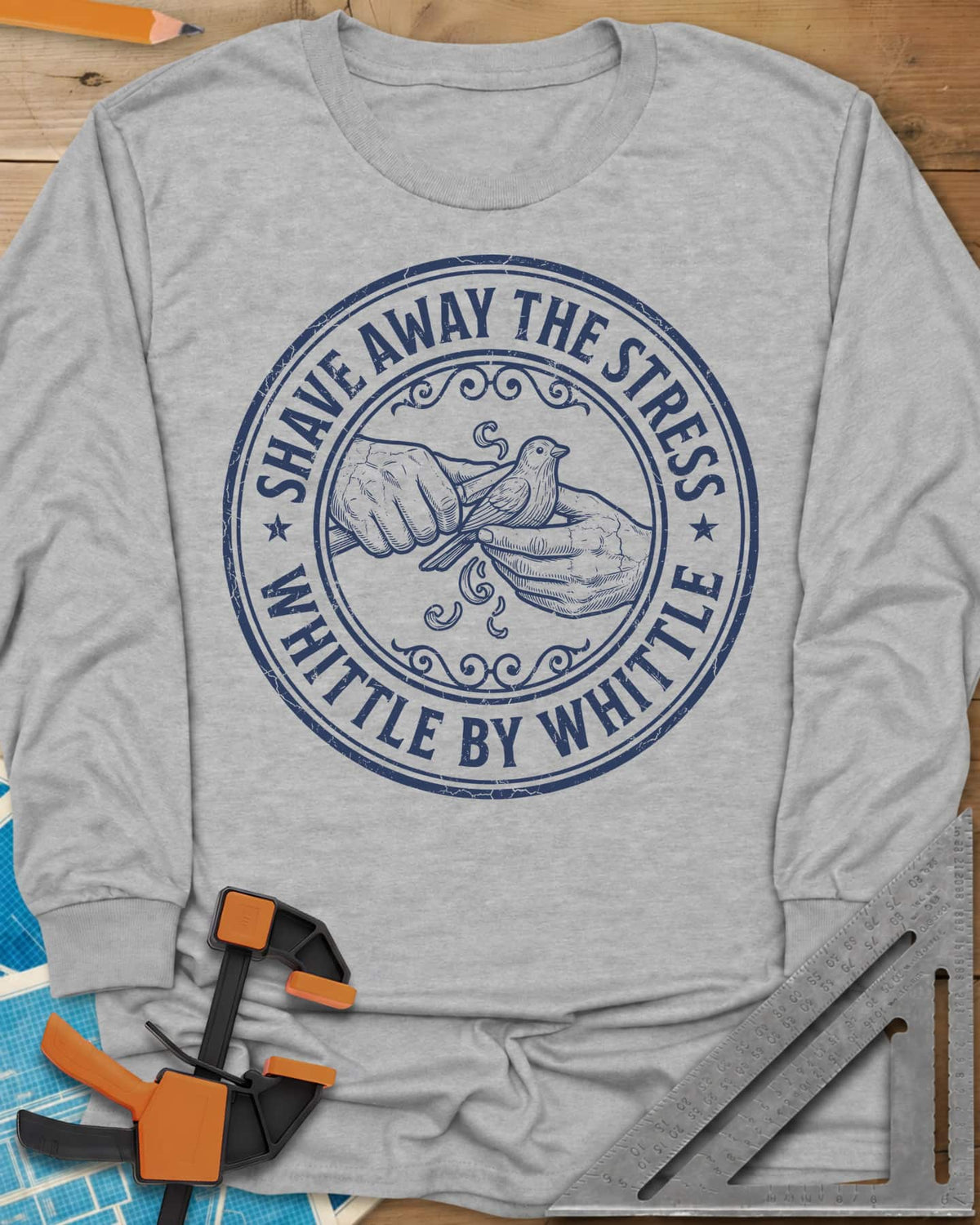 Whittle by Whittle long sleeve shirt in Sport Grey, two hands whittling a small bird inside a round distressed badge
