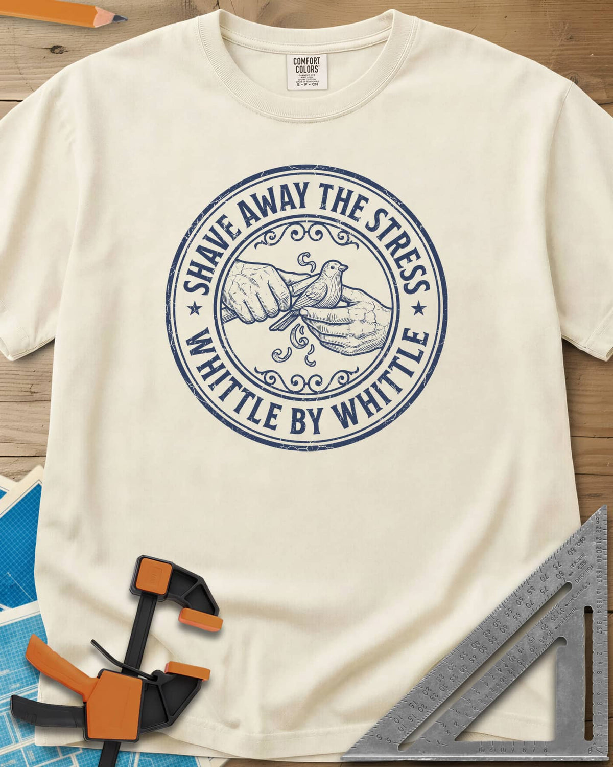 Whittle by Whittle heavyweight tee in Ivory, two hands whittling a small bird inside a round distressed badge