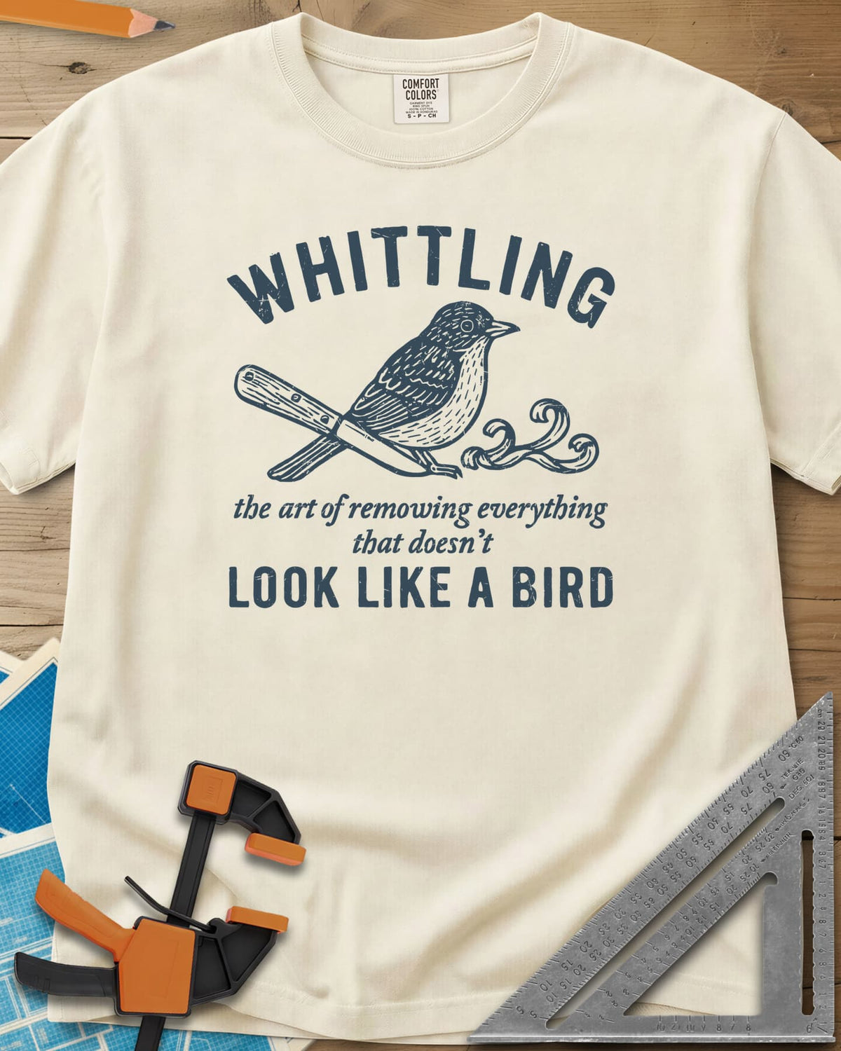 Whittling Art heavyweight tee in Ivory, an engraved songbird perched on a carving knife and wood curl