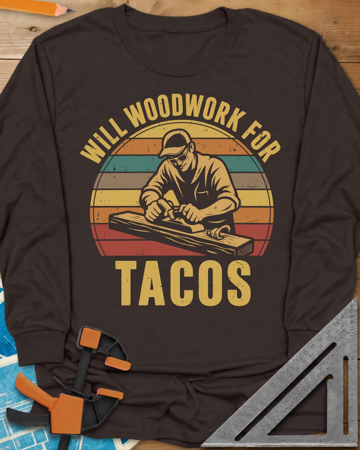 Will Woodwork For Tacos long sleeve shirt in Dark Chocolate, a capped woodworker planing a board before retro sunset stripes